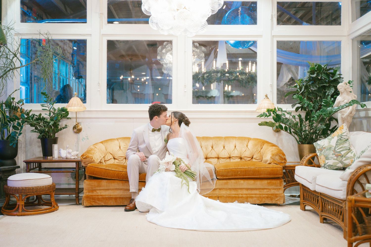 Wedding venue interior with tan leather couches and large windows creating a bright, airy atmosphere.