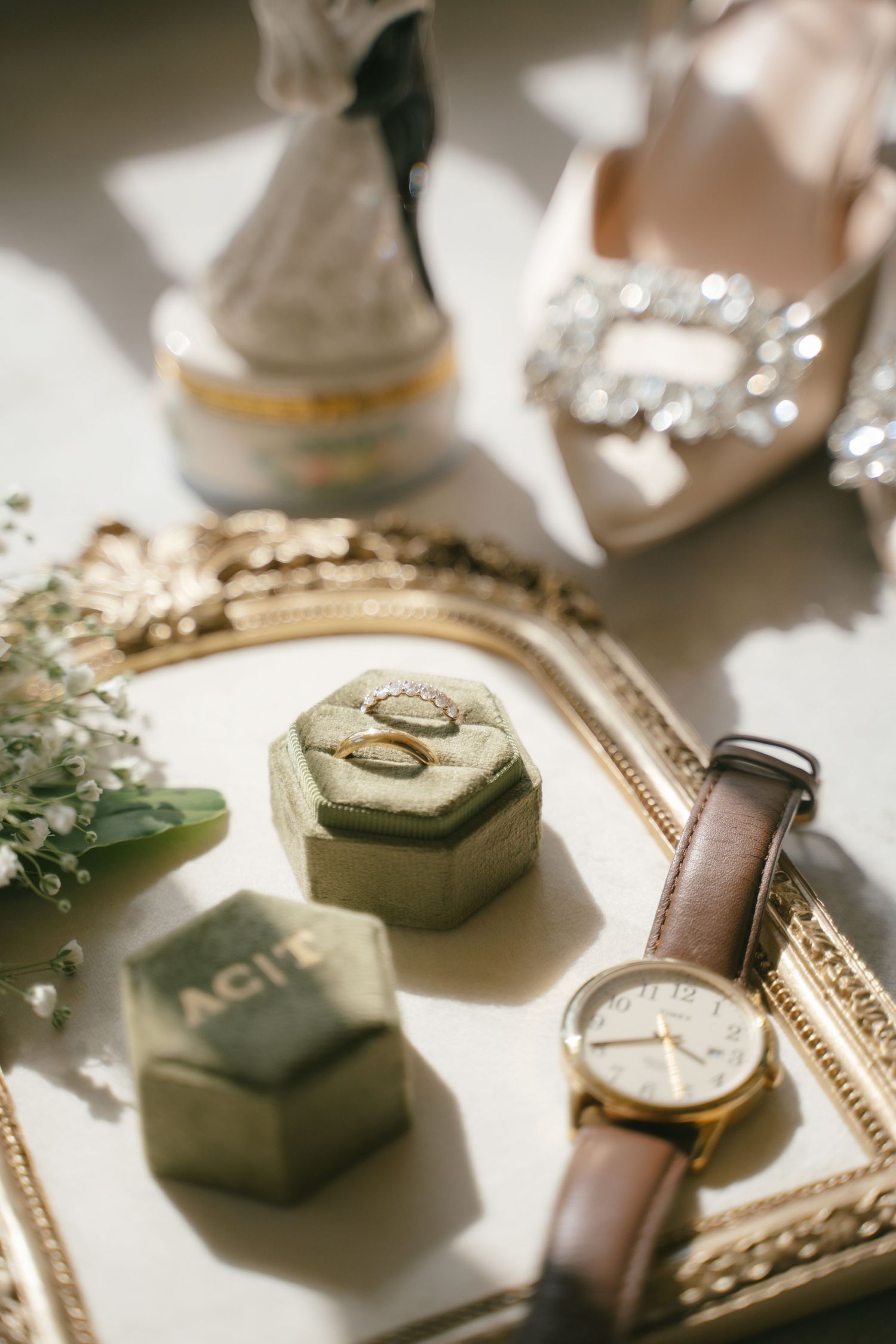Wedding accessories including watches, rings, and jewelry boxes arranged in natural light.