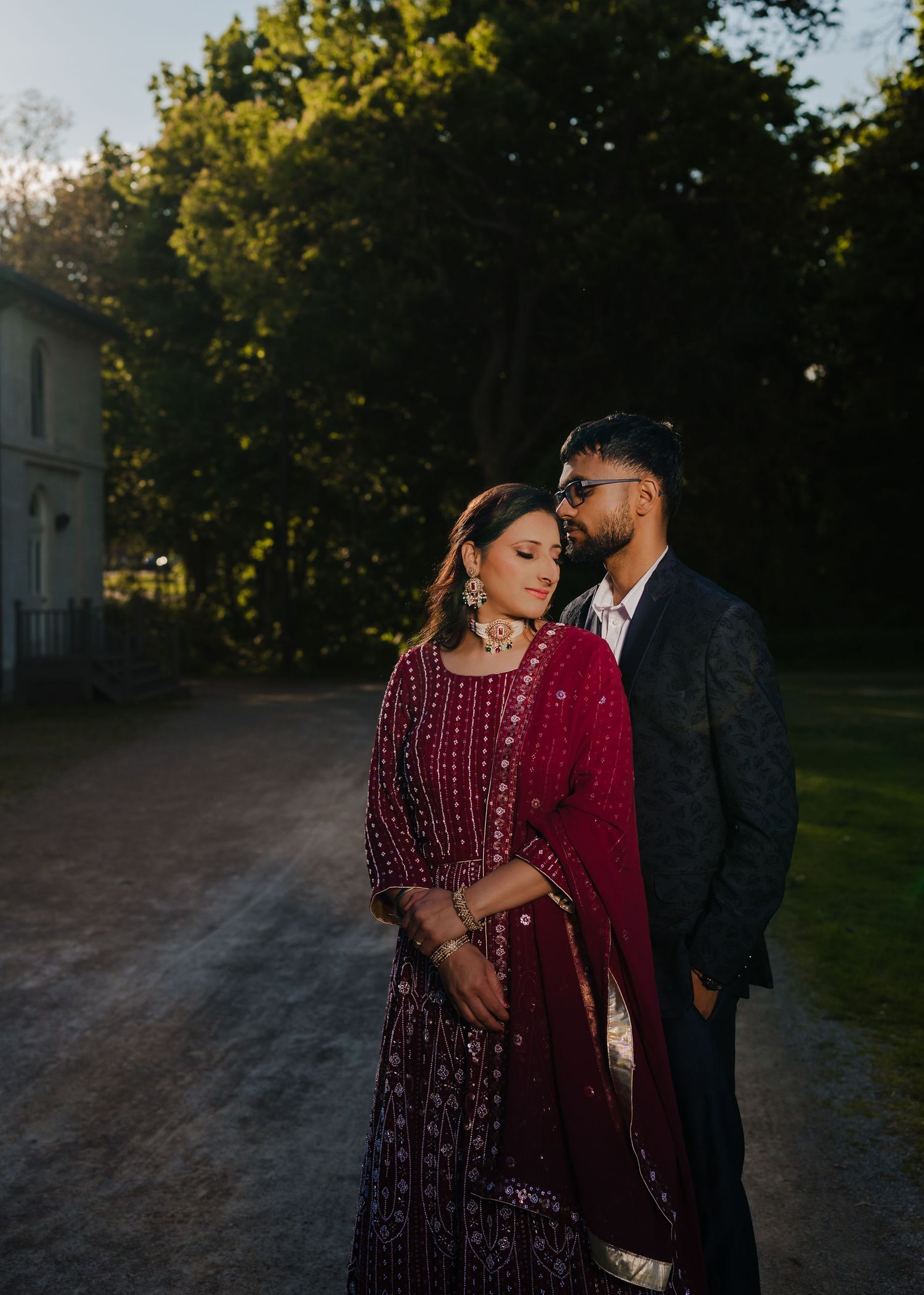Romantic evening photoshoot in a park setting with golden sunset lighting.