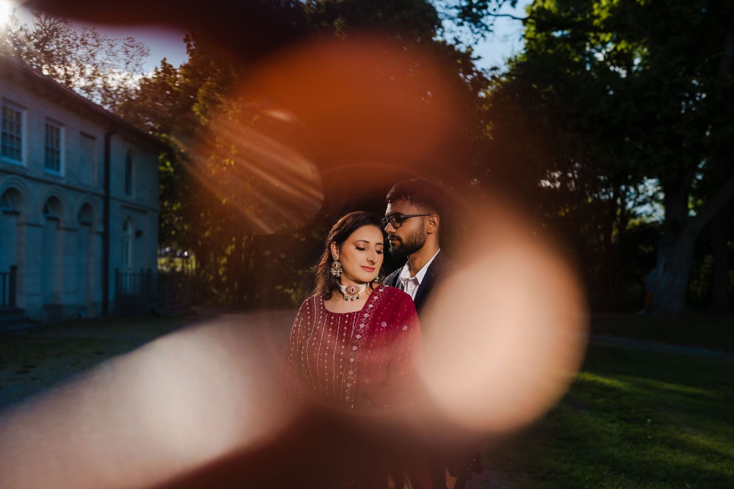 Artistic silhouette photography with dramatic sun flare and bokeh effects in an outdoor setting.