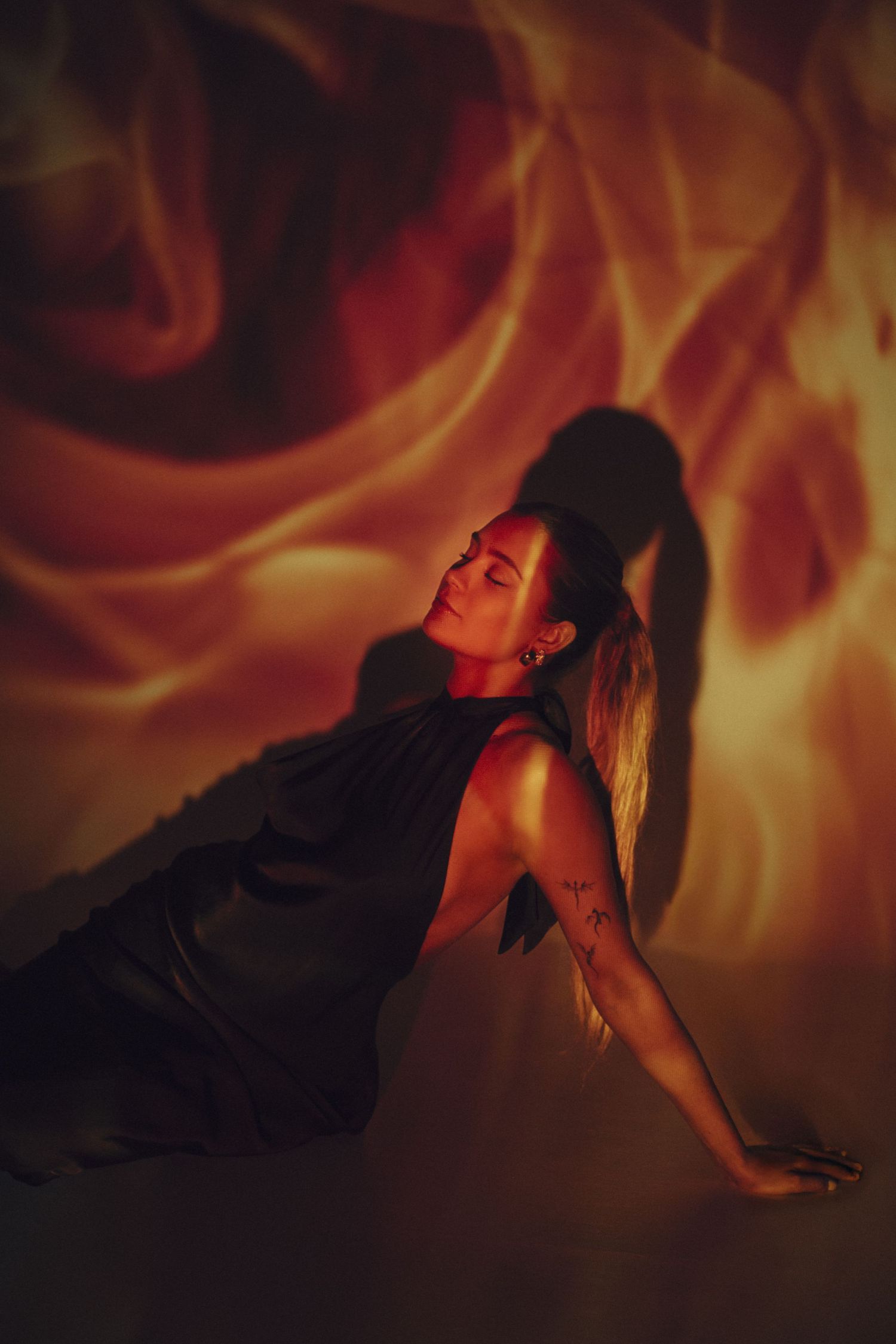 Dramatic portrait series with warm orange flames and dark shadows creating moody ambiance.