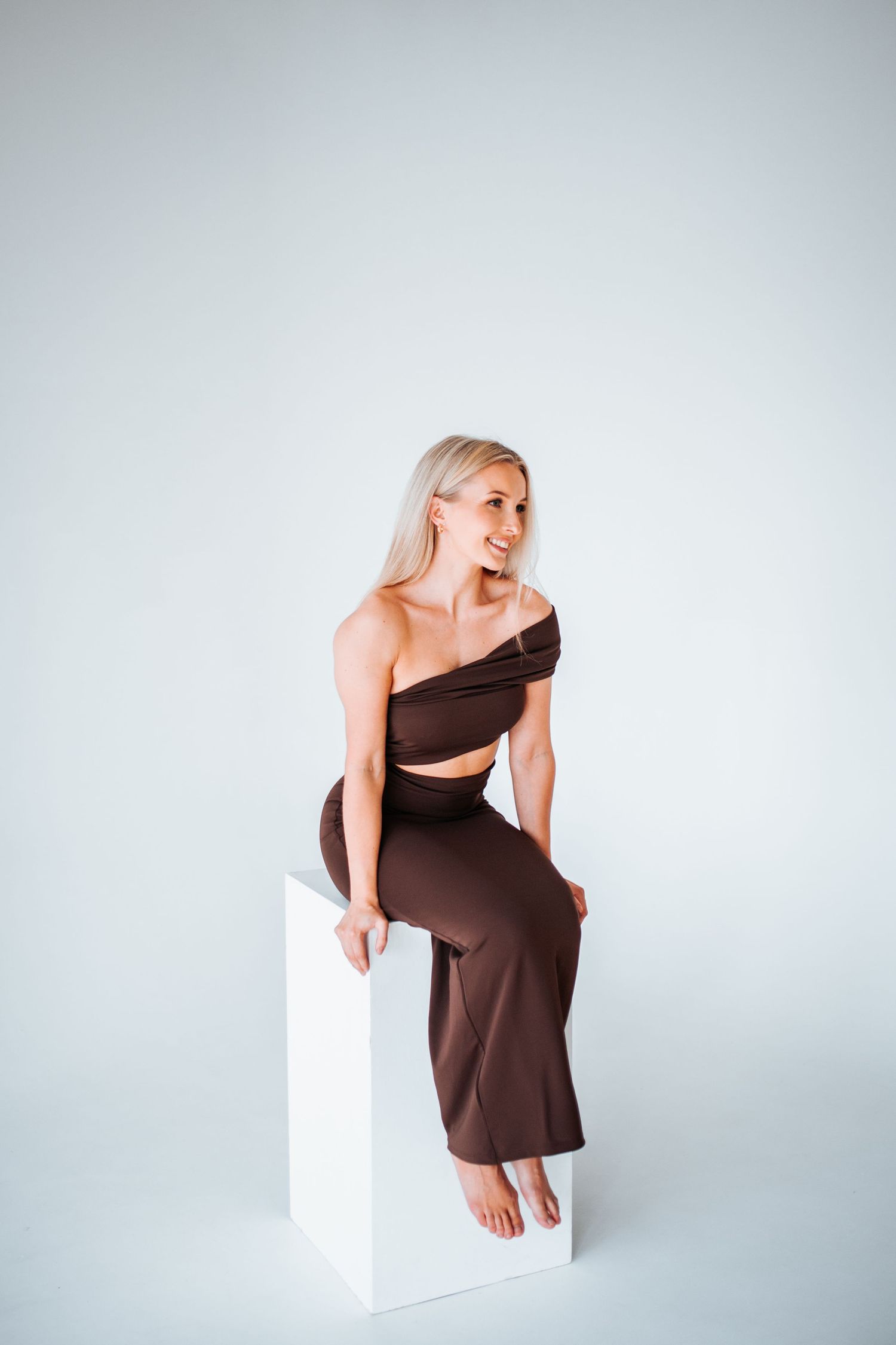 Fashion series showing a model in a brown dress posing against a white backdrop.