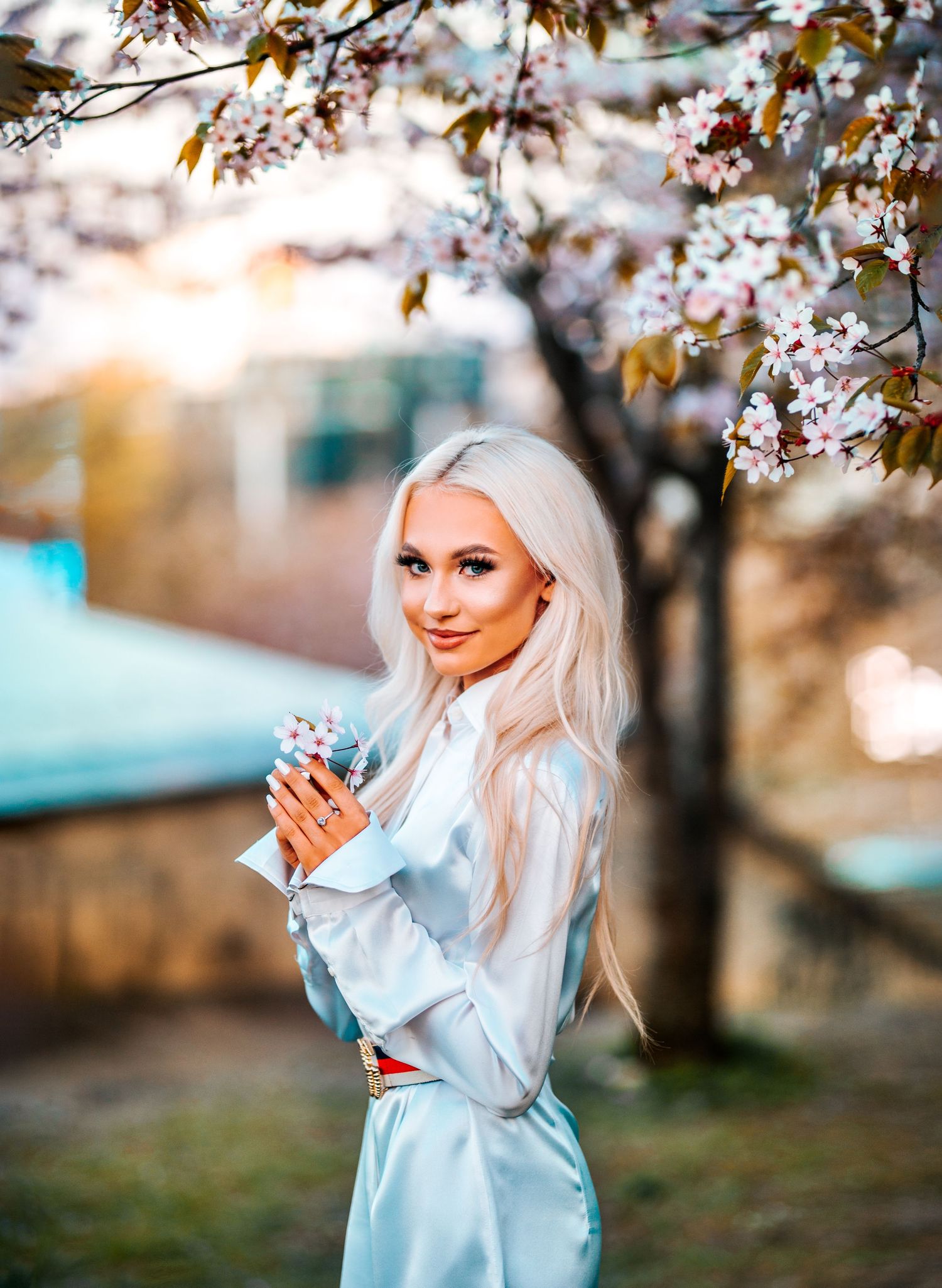 Spring portrait series with cherry blossoms and soft natural lighting in a park setting.