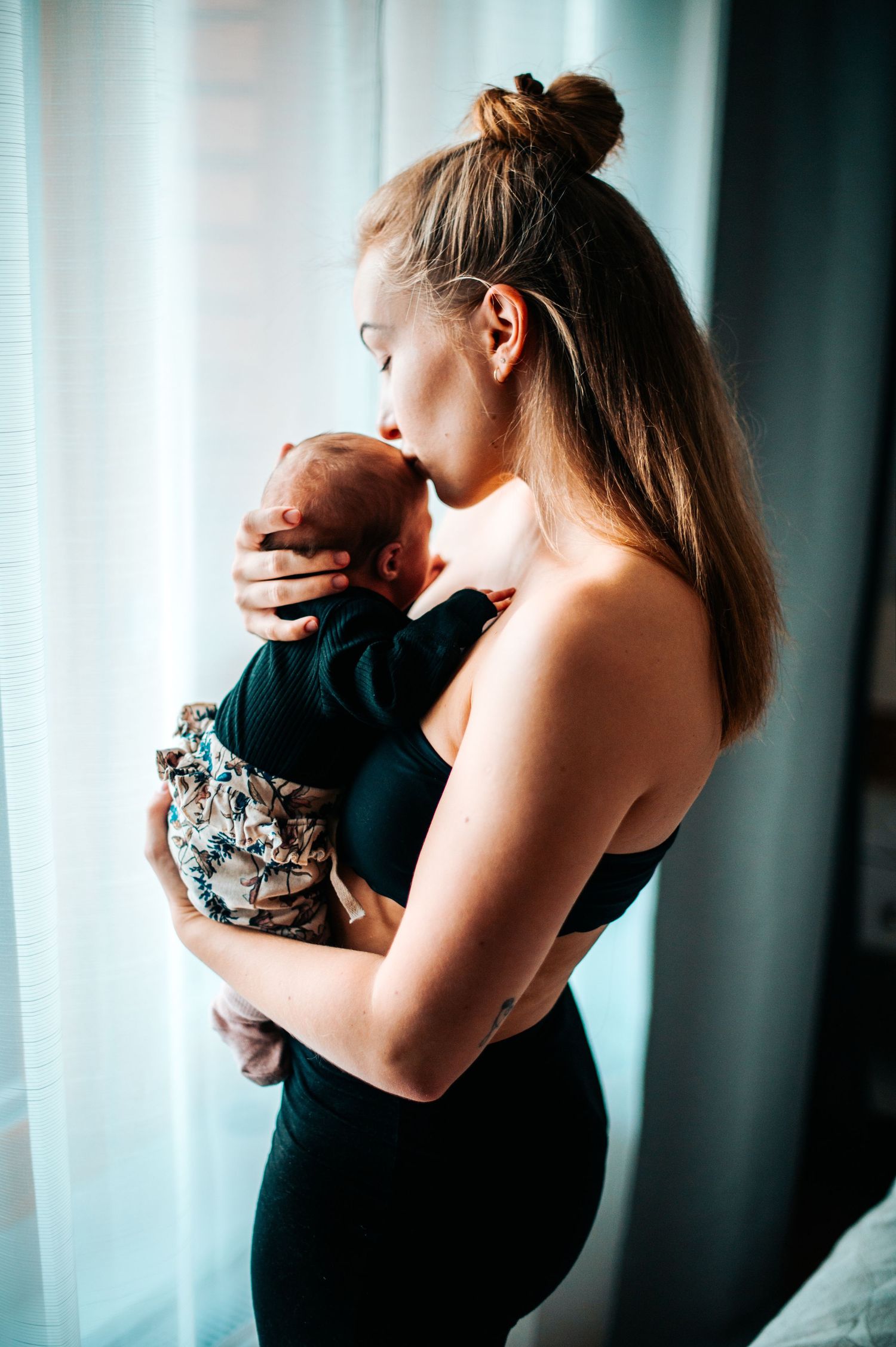 Intimate portrait of tender moment against soft window light.