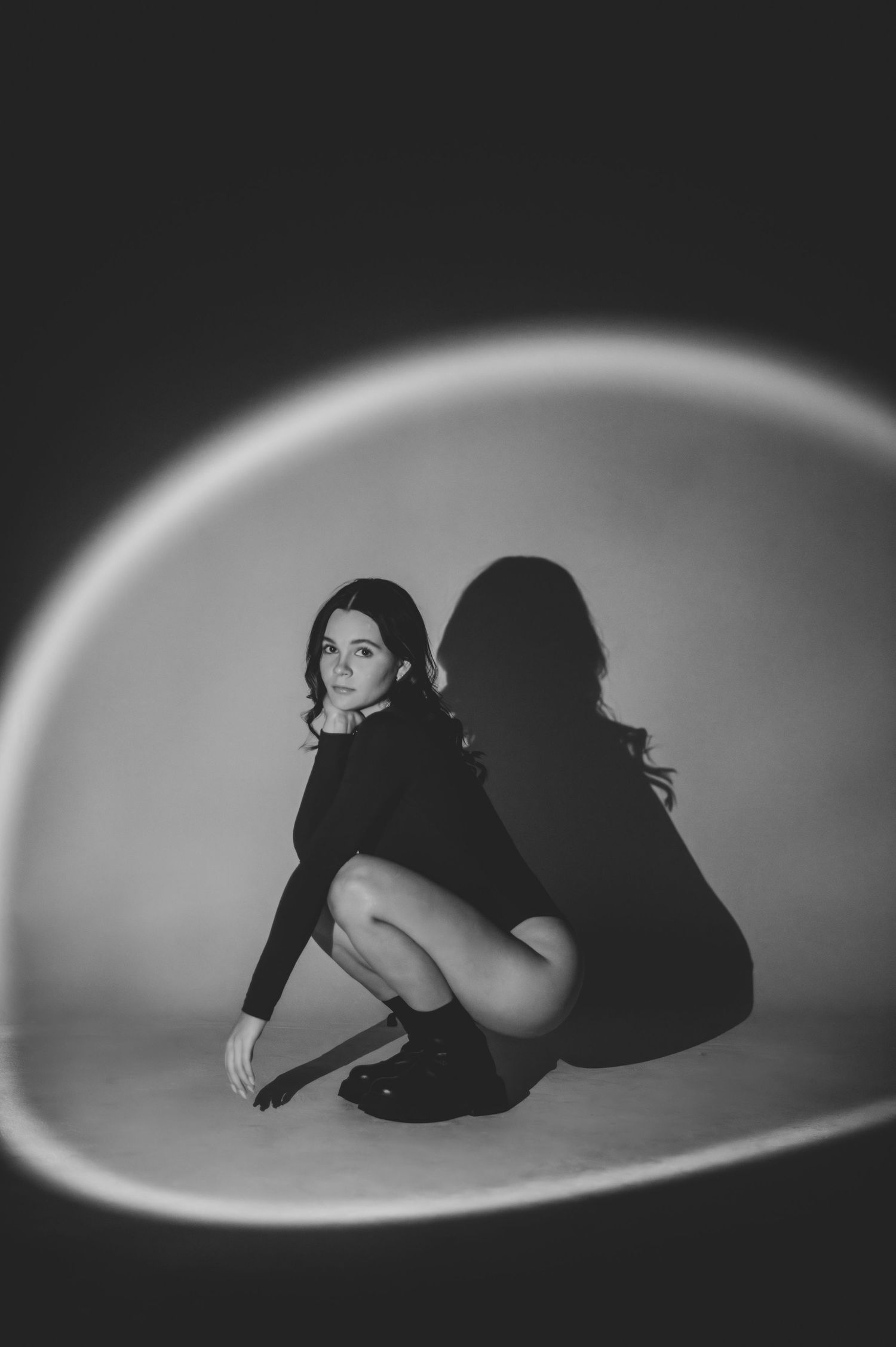 Artistic black and white photography series with dramatic oval spotlight effects.