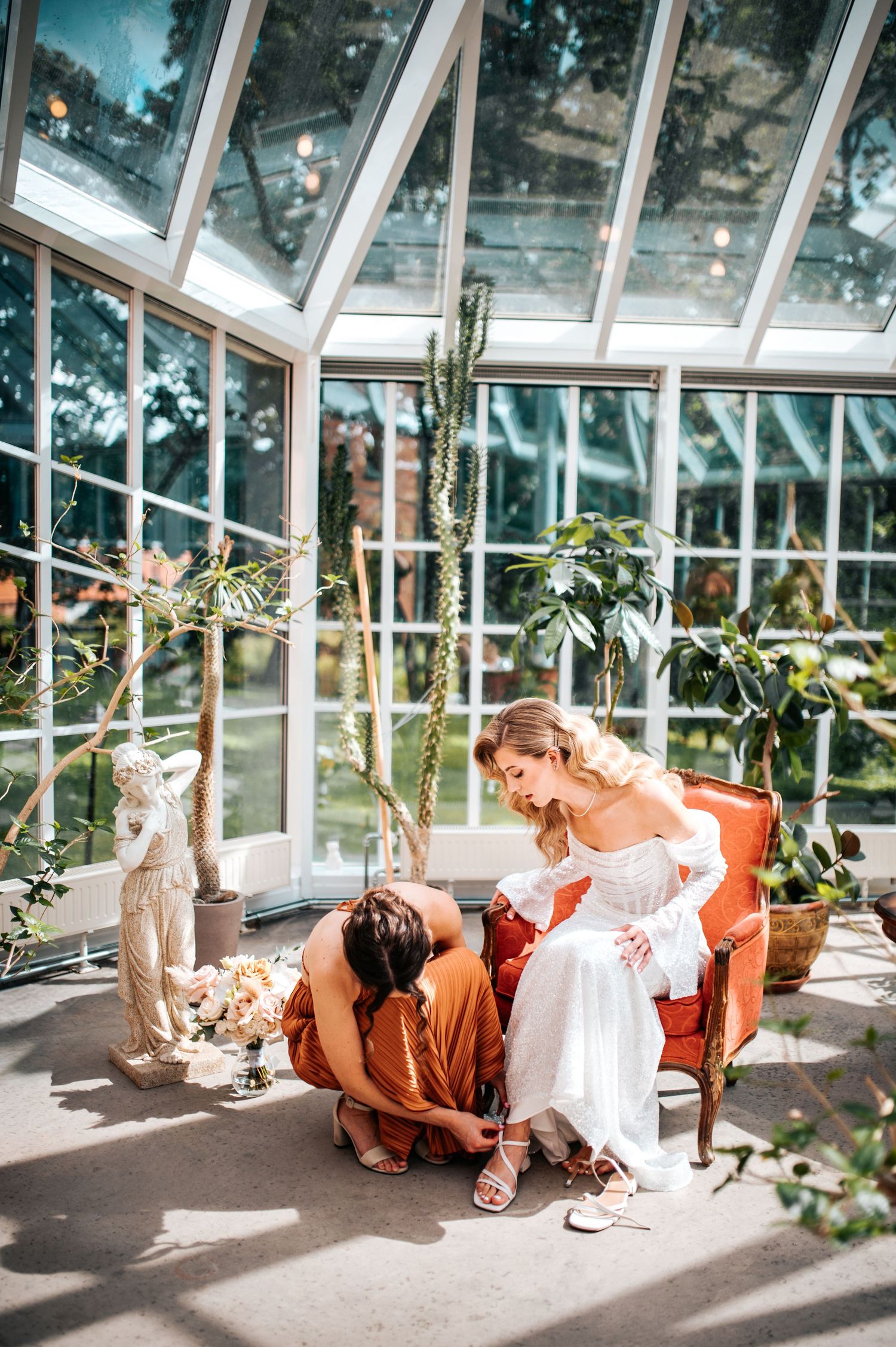 Sunlit greenhouse interior with decorative elements and plants creating a romantic atmosphere.