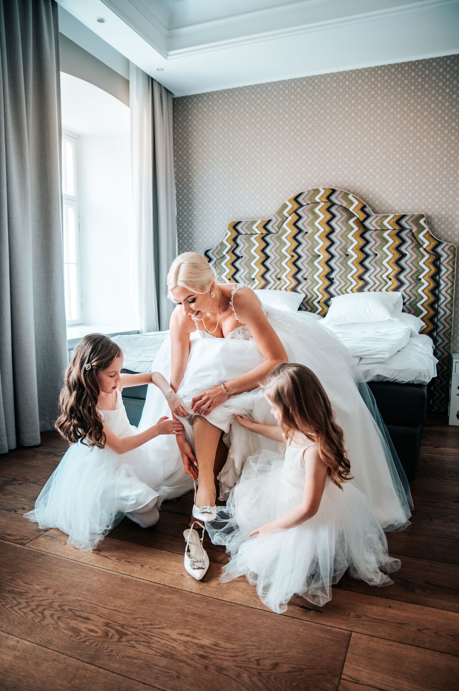 Wedding preparations captured in an elegant hotel room with hardwood floors.