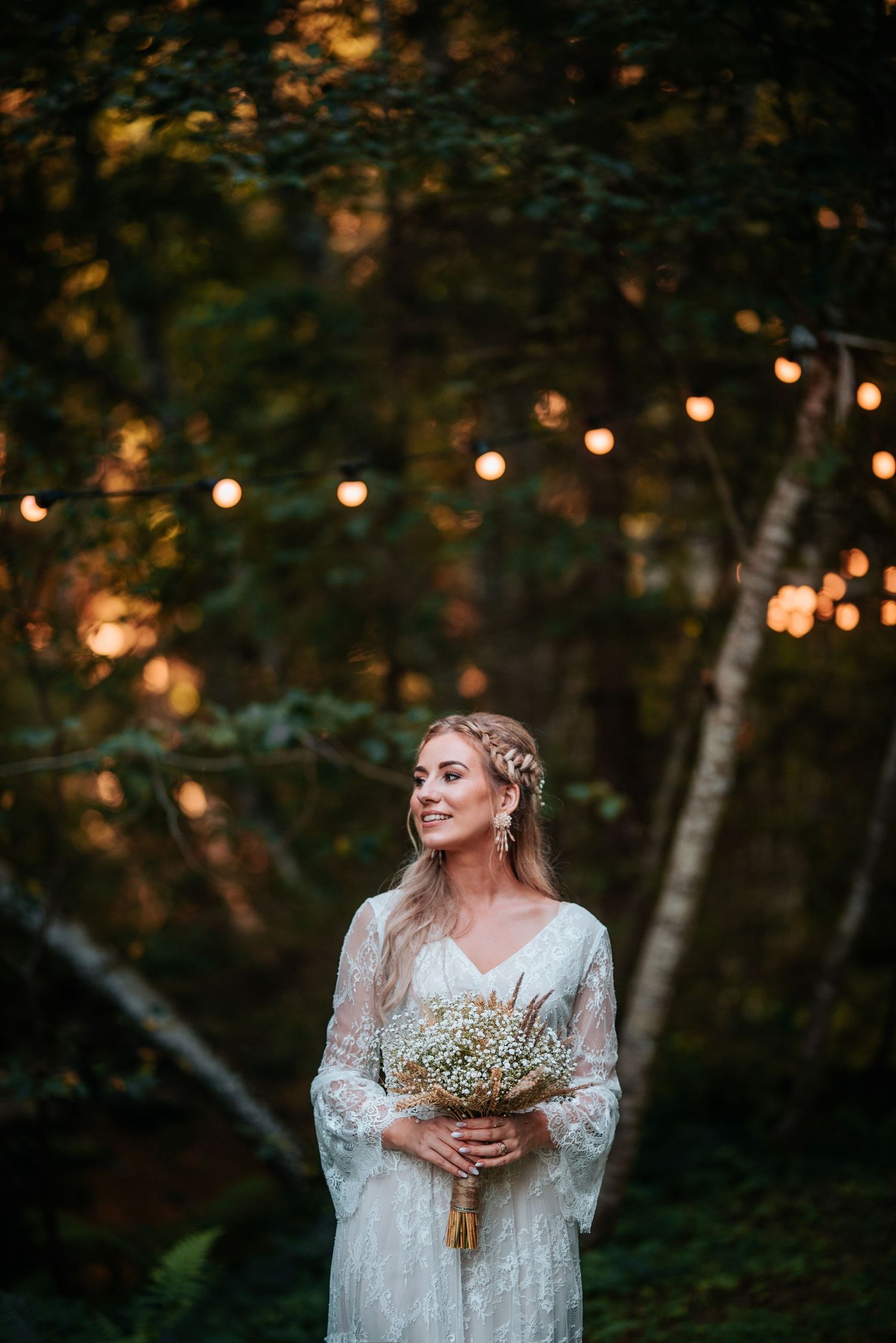 Ethereal forest wedding scene with string lights and delicate lace details.
