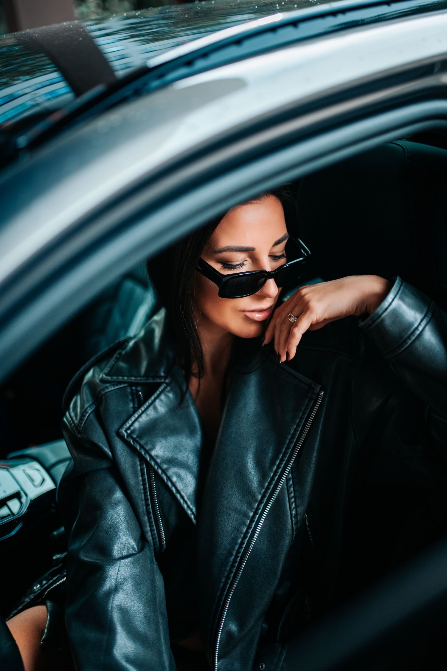 Artistic close-up shots of a person in a black leather jacket inside a car with moody lighting.