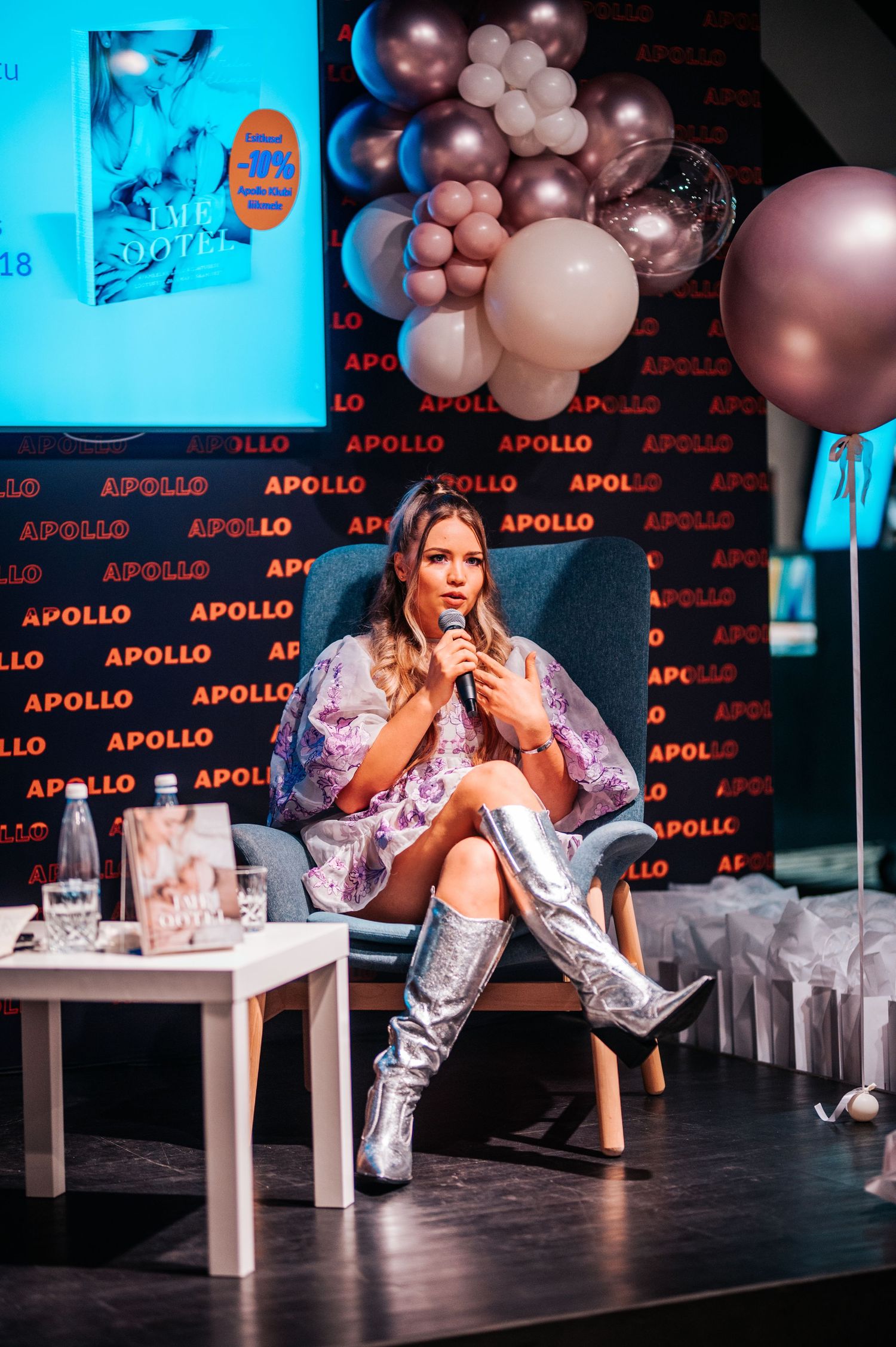 Event stage setup with pink balloon decorations and Apollo branding backdrop.