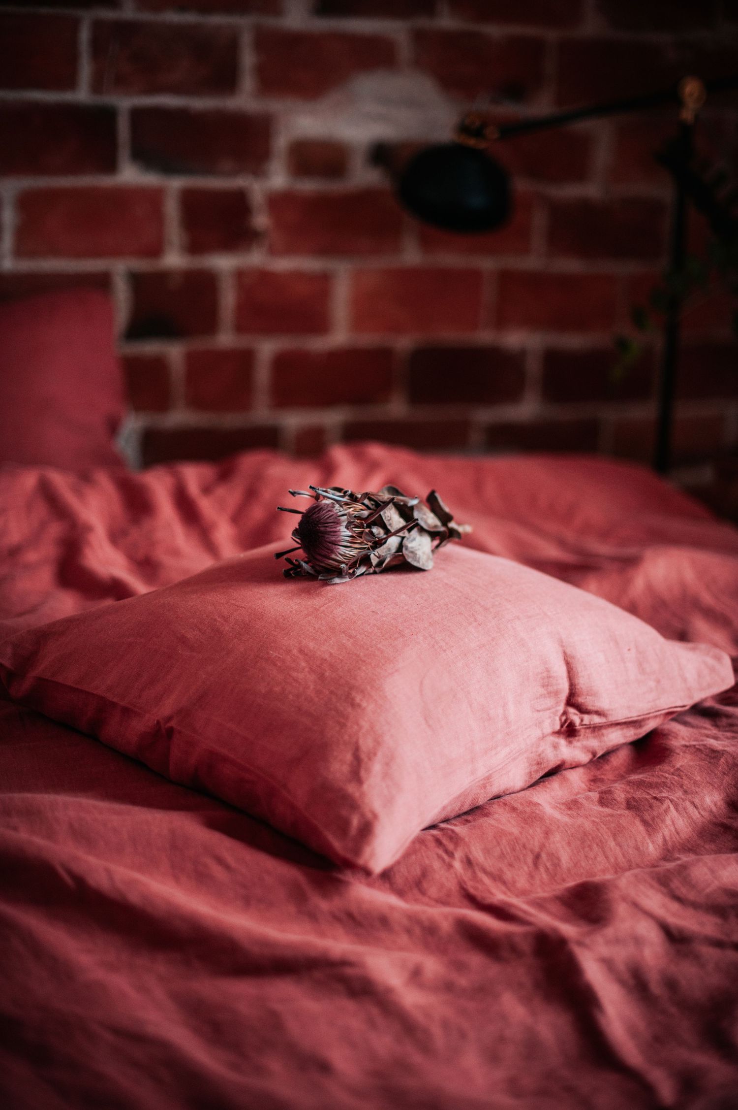 Pink linen bedding with decorative elements creating cozy bedroom atmosphere.