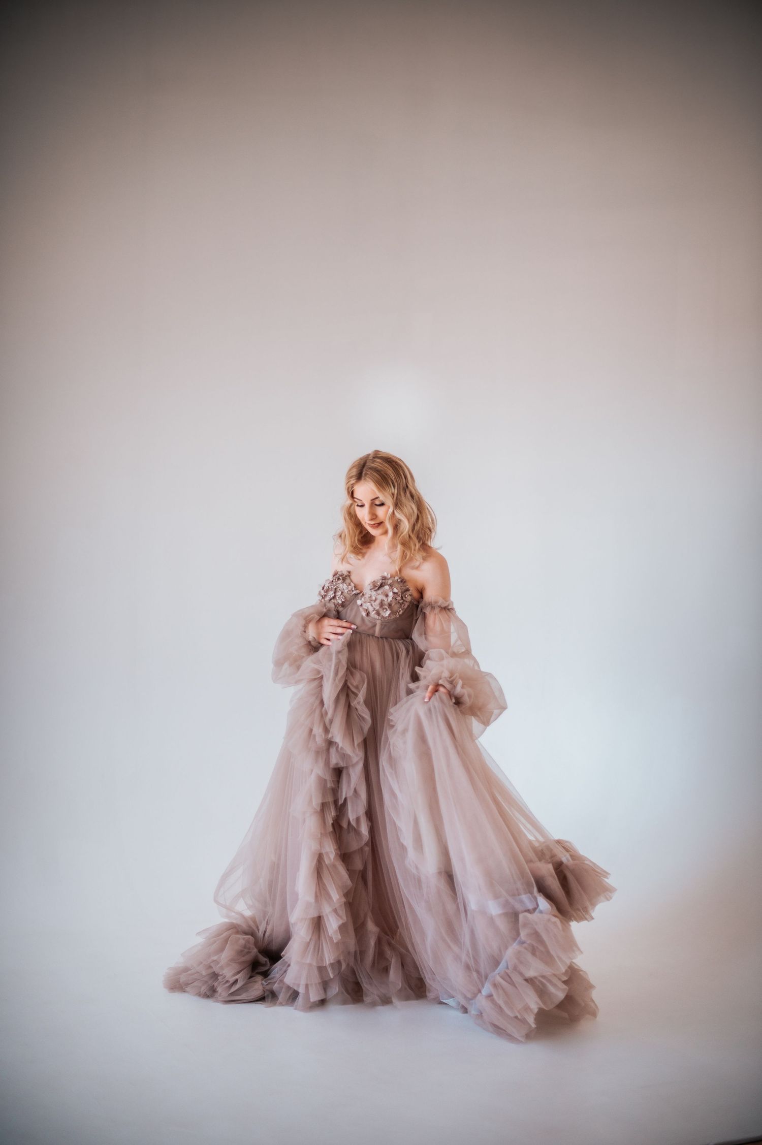 Elegant portrait series featuring a flowing blush-colored gown against a neutral background.