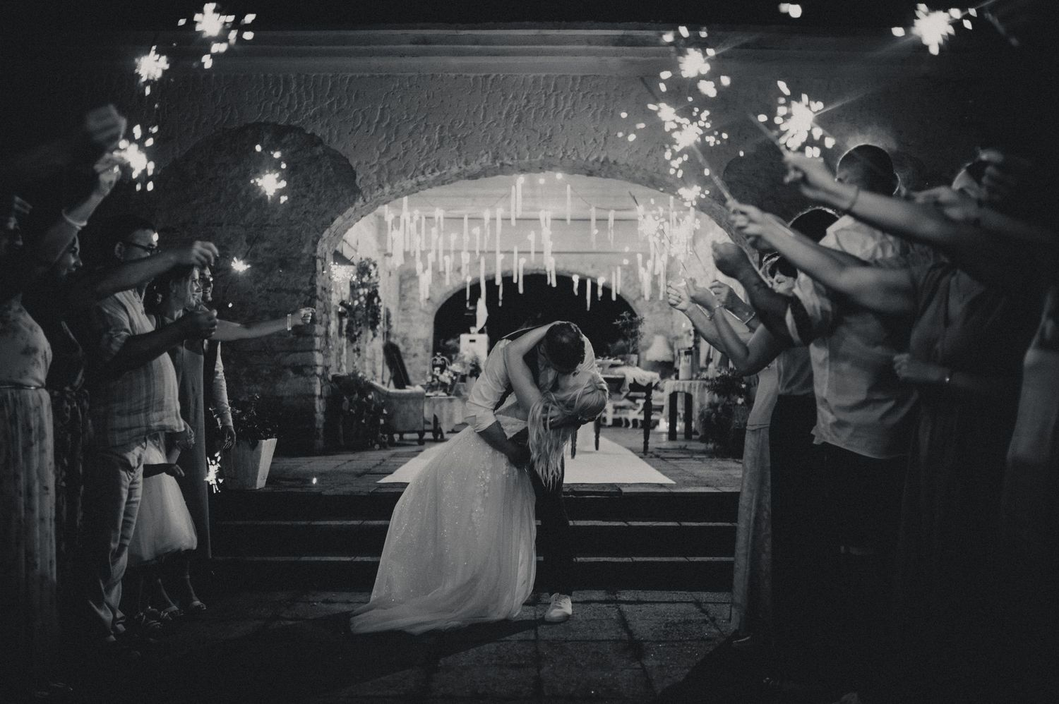 Black and white wedding reception photos show couples dancing under twinkling lights and decorations at night.