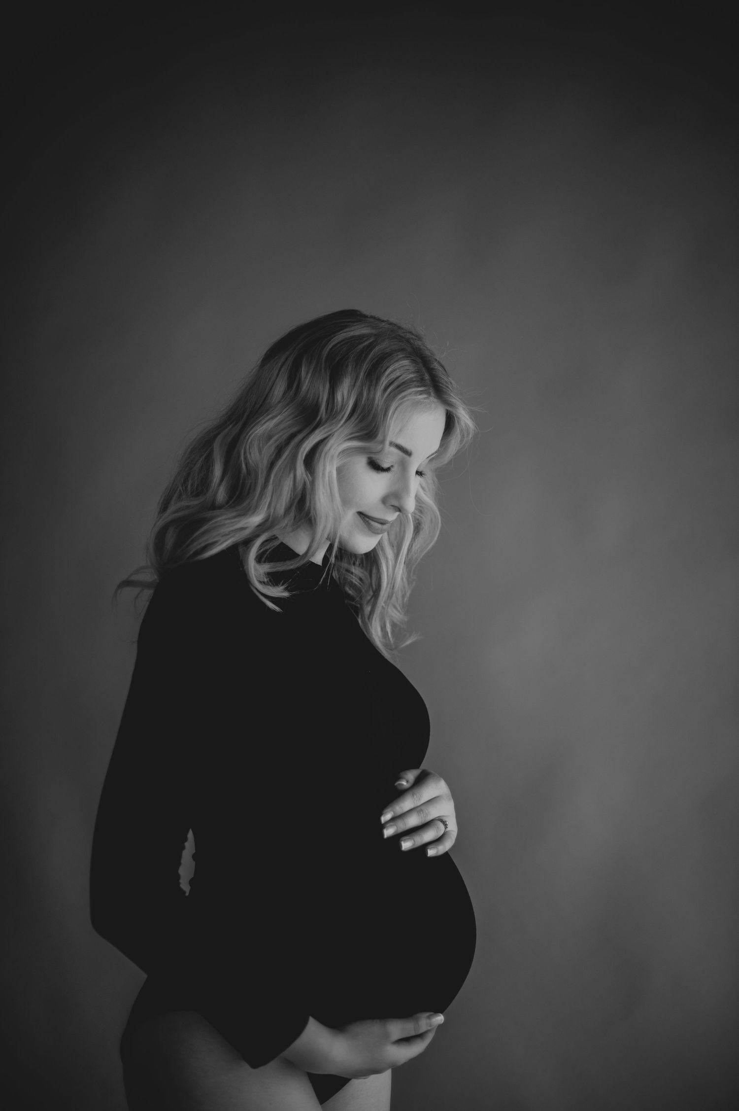Black and white portrait series showing dramatic poses and movements in dark lighting against a shadowy background.