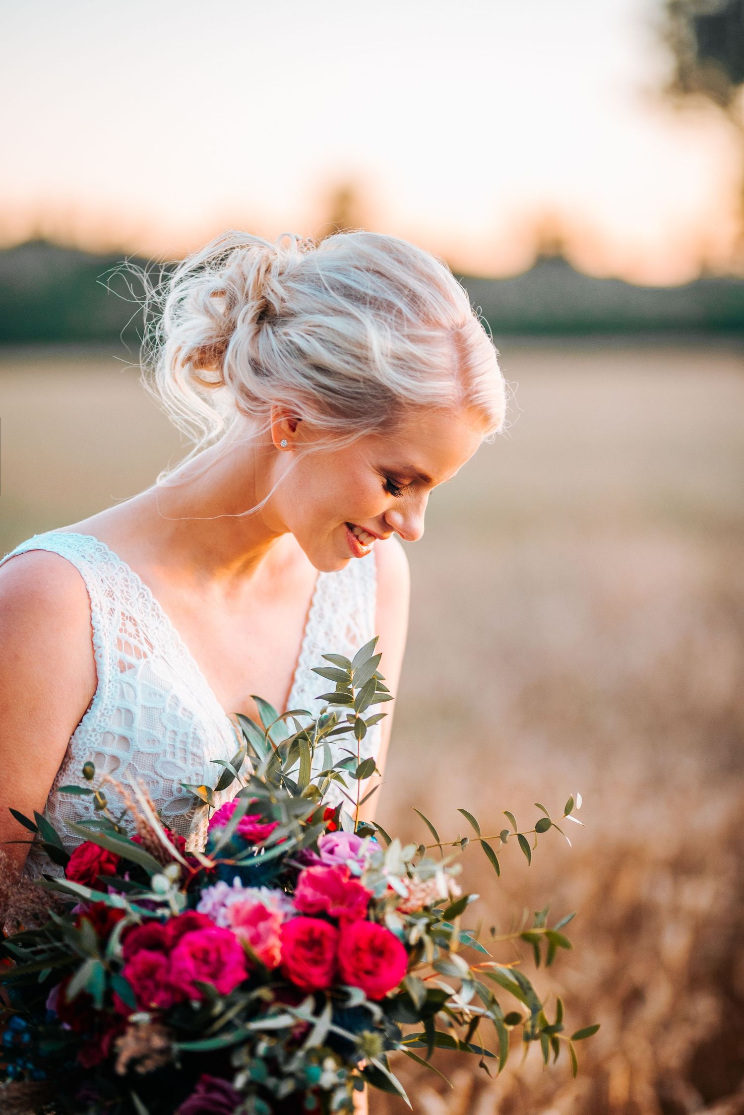 A stunning bridal portrait with vibrant pink roses in golden evening light.