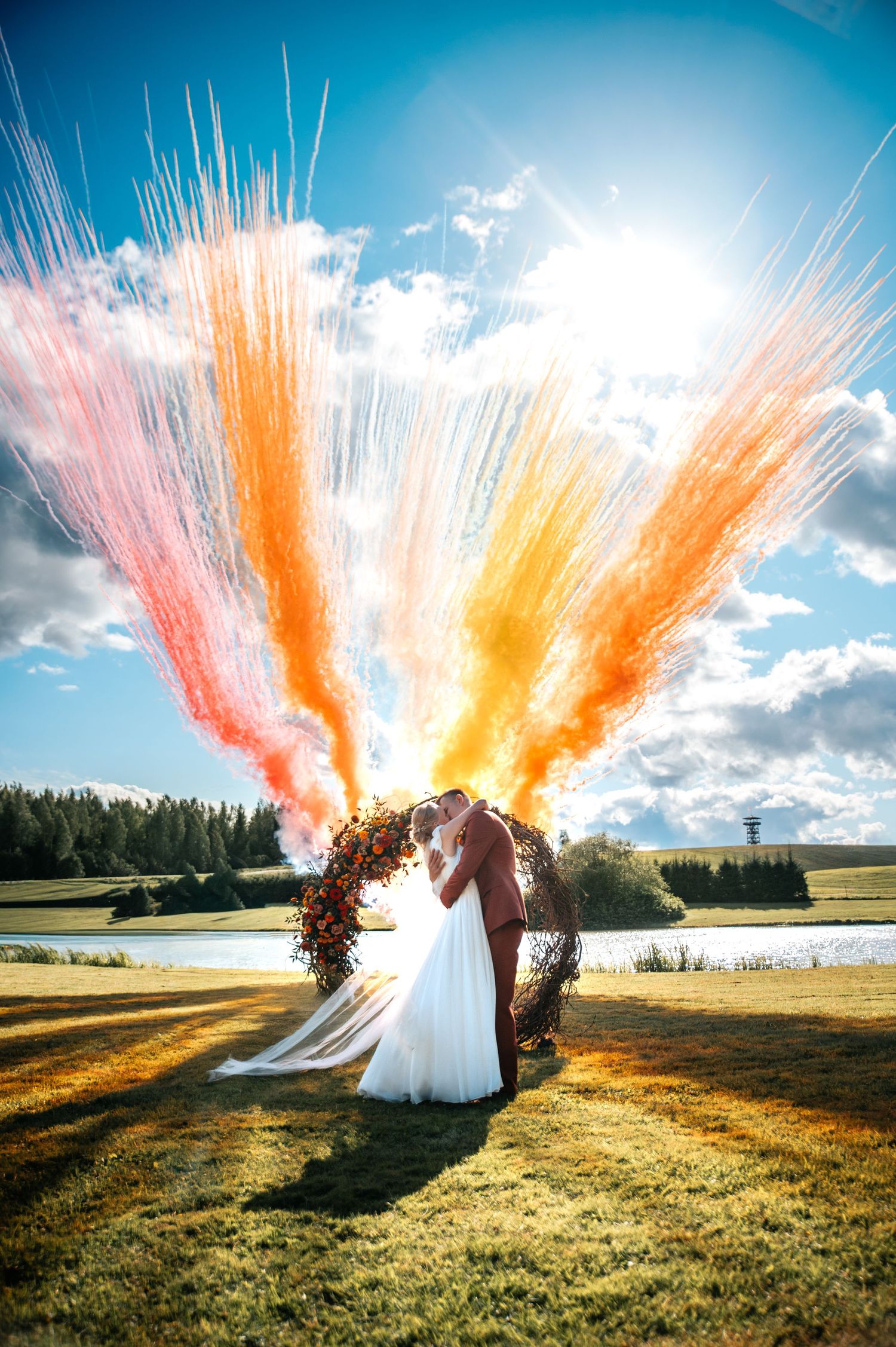 Colorful smoke bombs create dramatic effect during outdoor wedding photography.