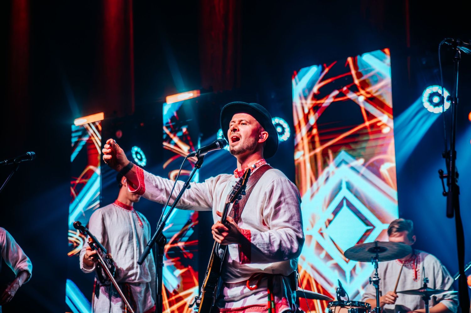 Concert performance with dramatic blue lighting and geometric stage design.