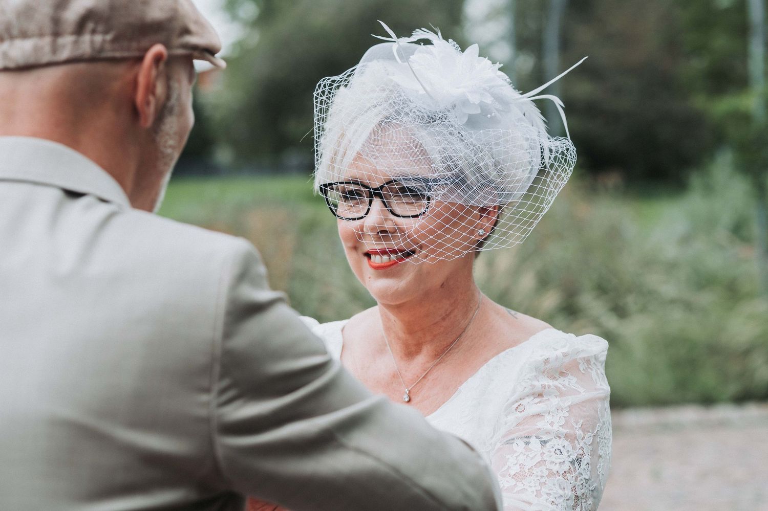 A happy couple shares a tender moment on their wedding day in an outdoor garden setting.