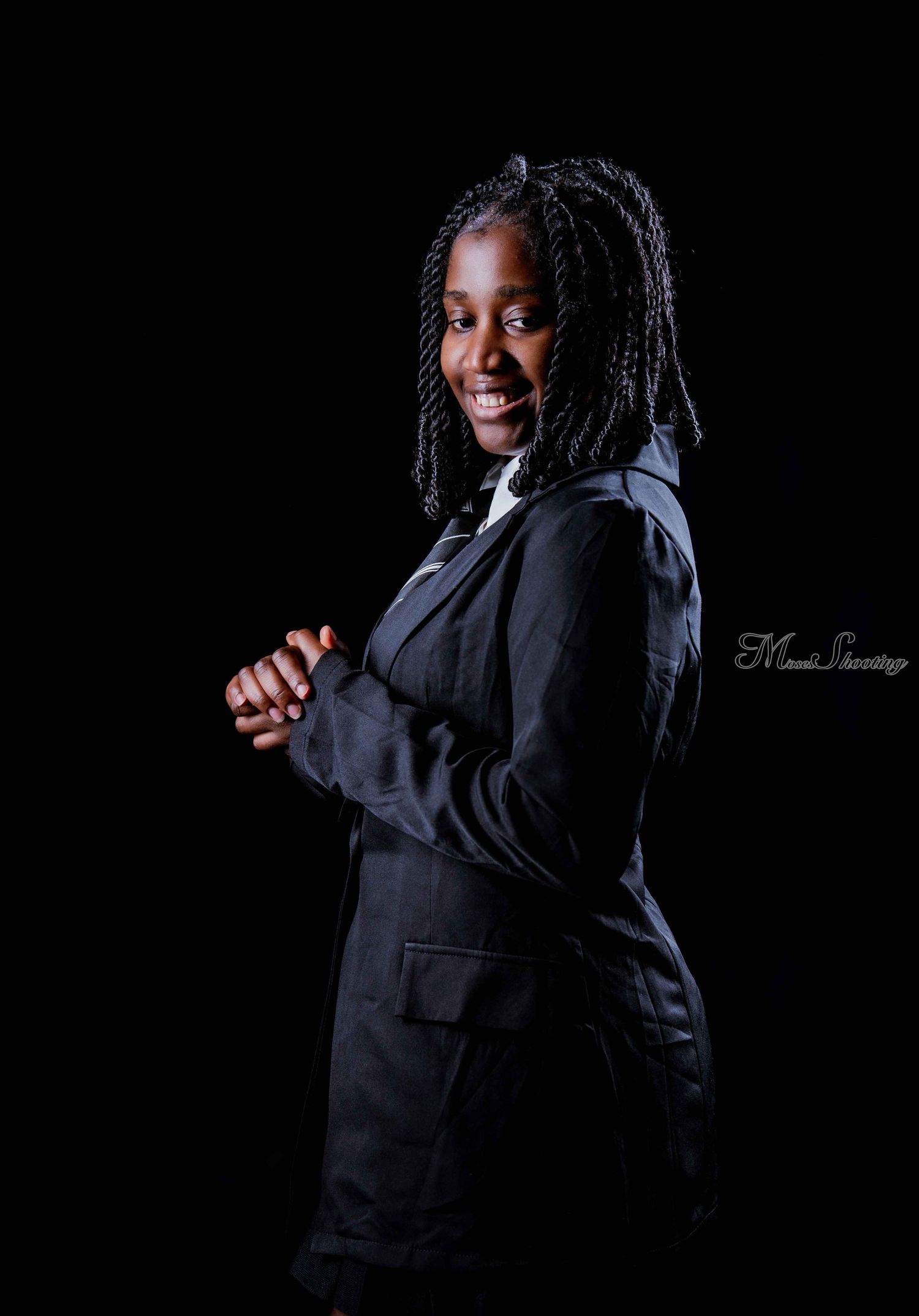 Professional portrait series against black background showcasing elegant poses in a dark business suit.