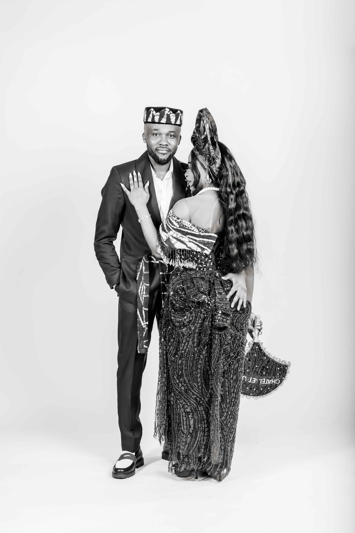 Black and white photo series showing a couple in formal attire posing together against a white backdrop.