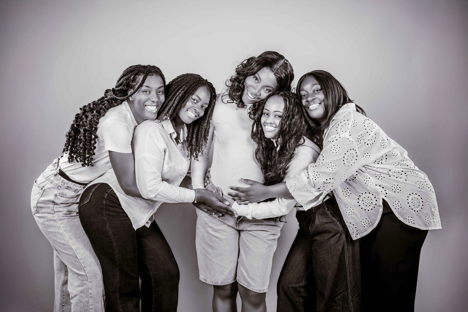 A series of black and white portrait photographs showing joyful interactions between people against a studio backdrop.
