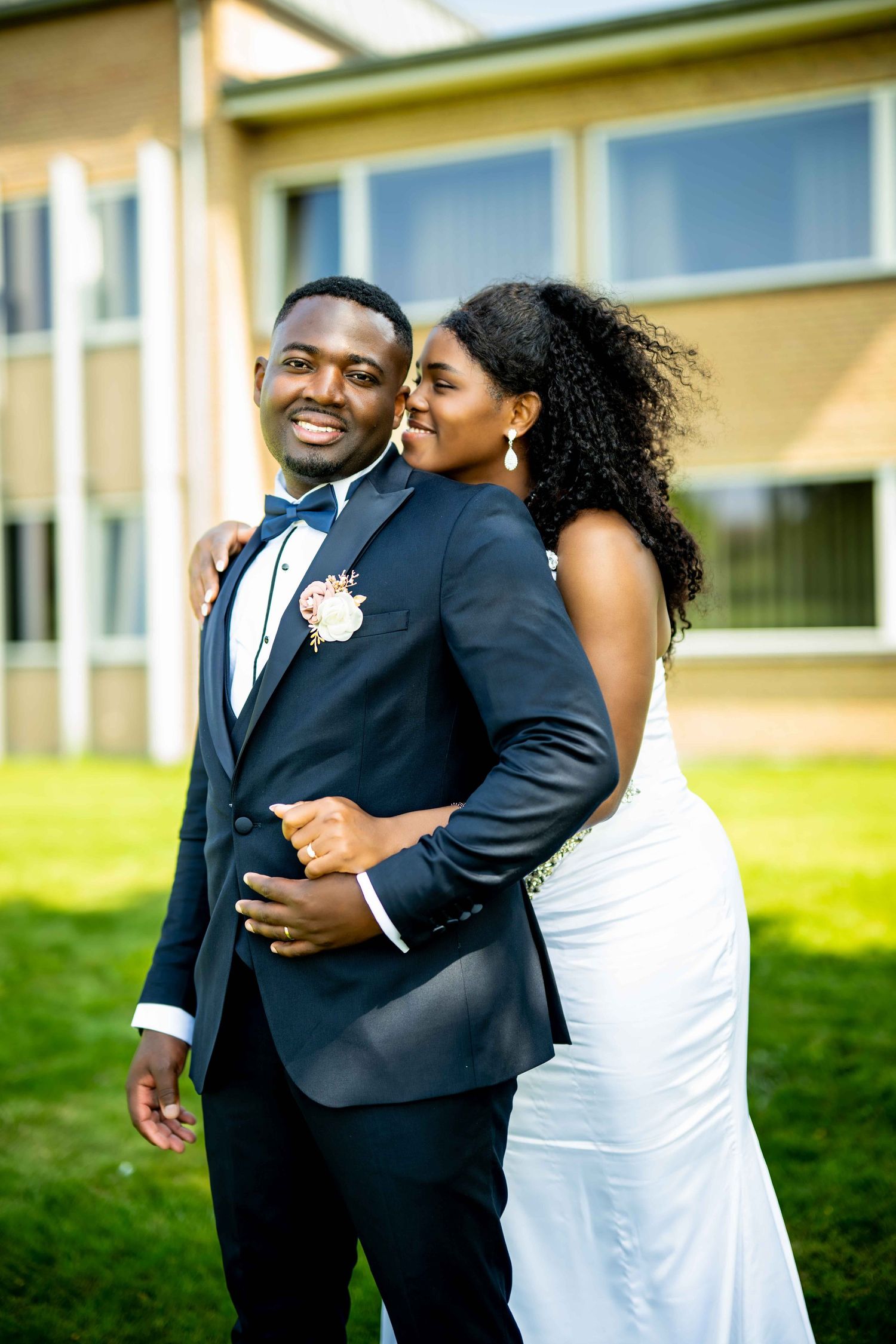 A joyful couple shares intimate moments in formal attire during an outdoor photo session.