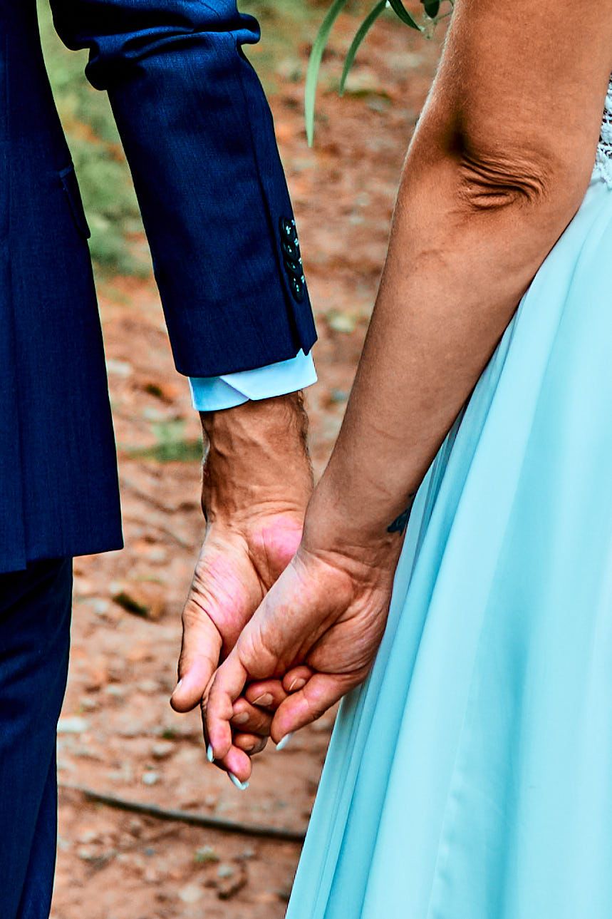 Close-up series of hands holding each other against a backdrop of blue dress and navy suit.