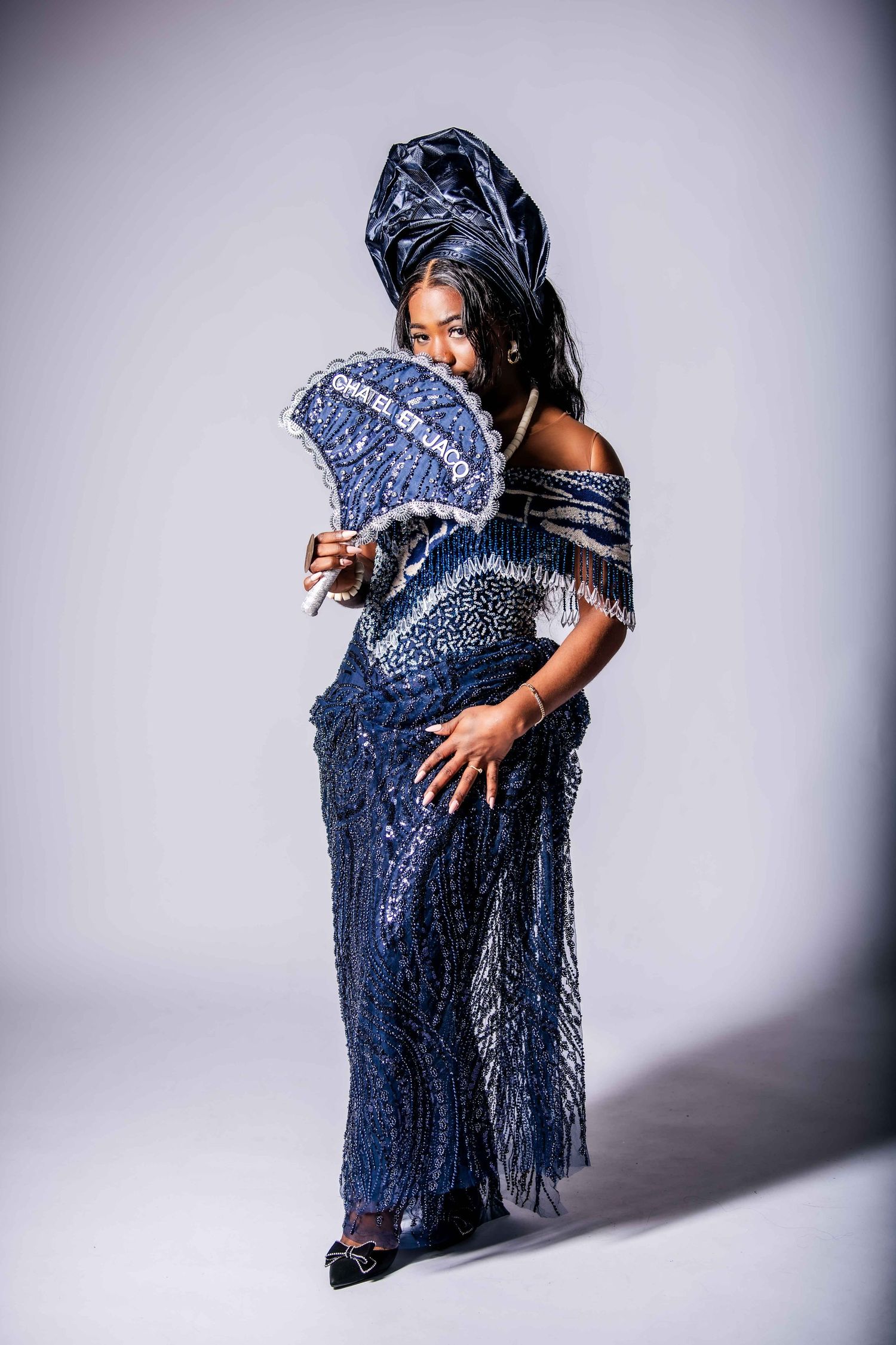 A figure in a sparkly navy dress poses dramatically in different positions against a light background.