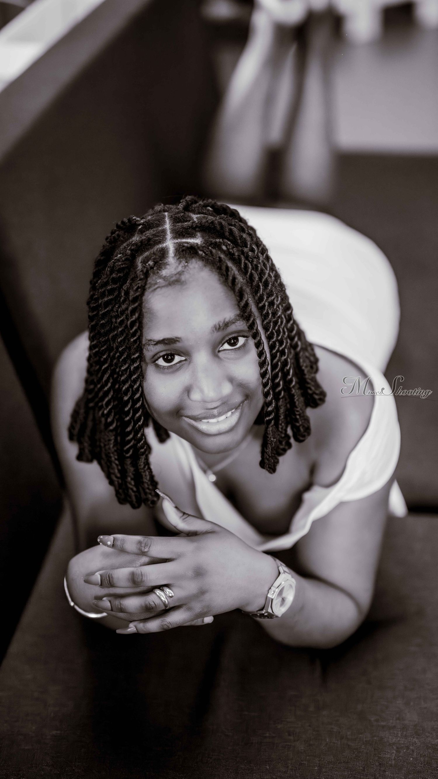 A series of black and white portraits showing someone with twisted braids in various relaxed poses against a dark background.