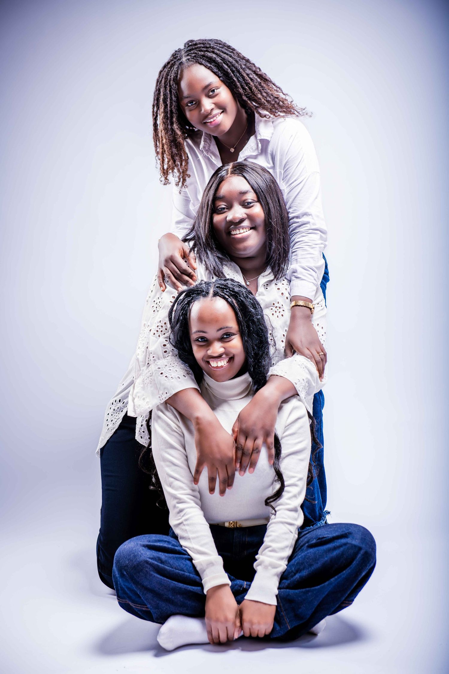 Joyful portrait series showing two people in white and blue outfits sharing warm embraces against light background.