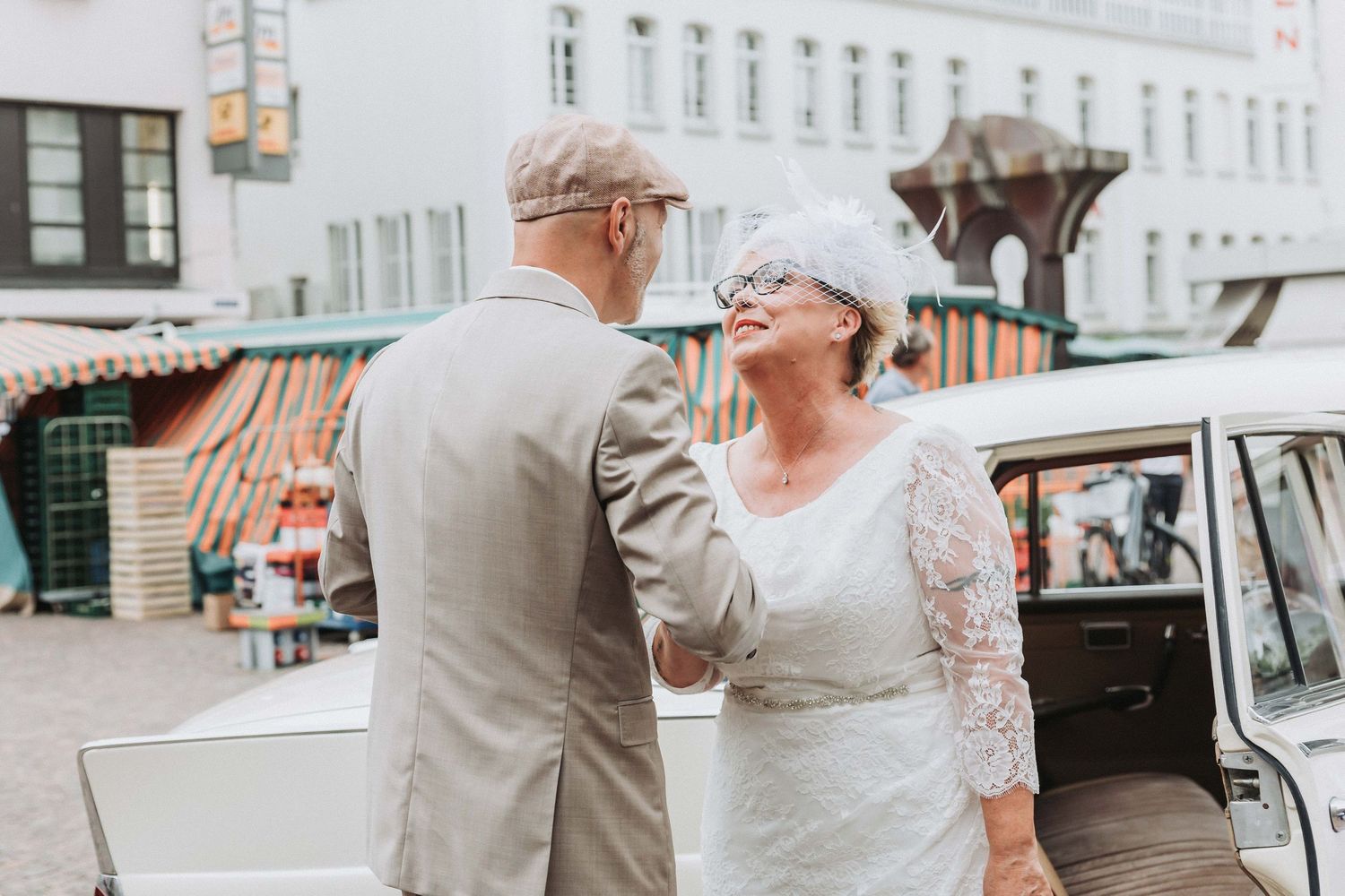 Elderly couple shares joyful moments together on their wedding day in vintage-style attire.