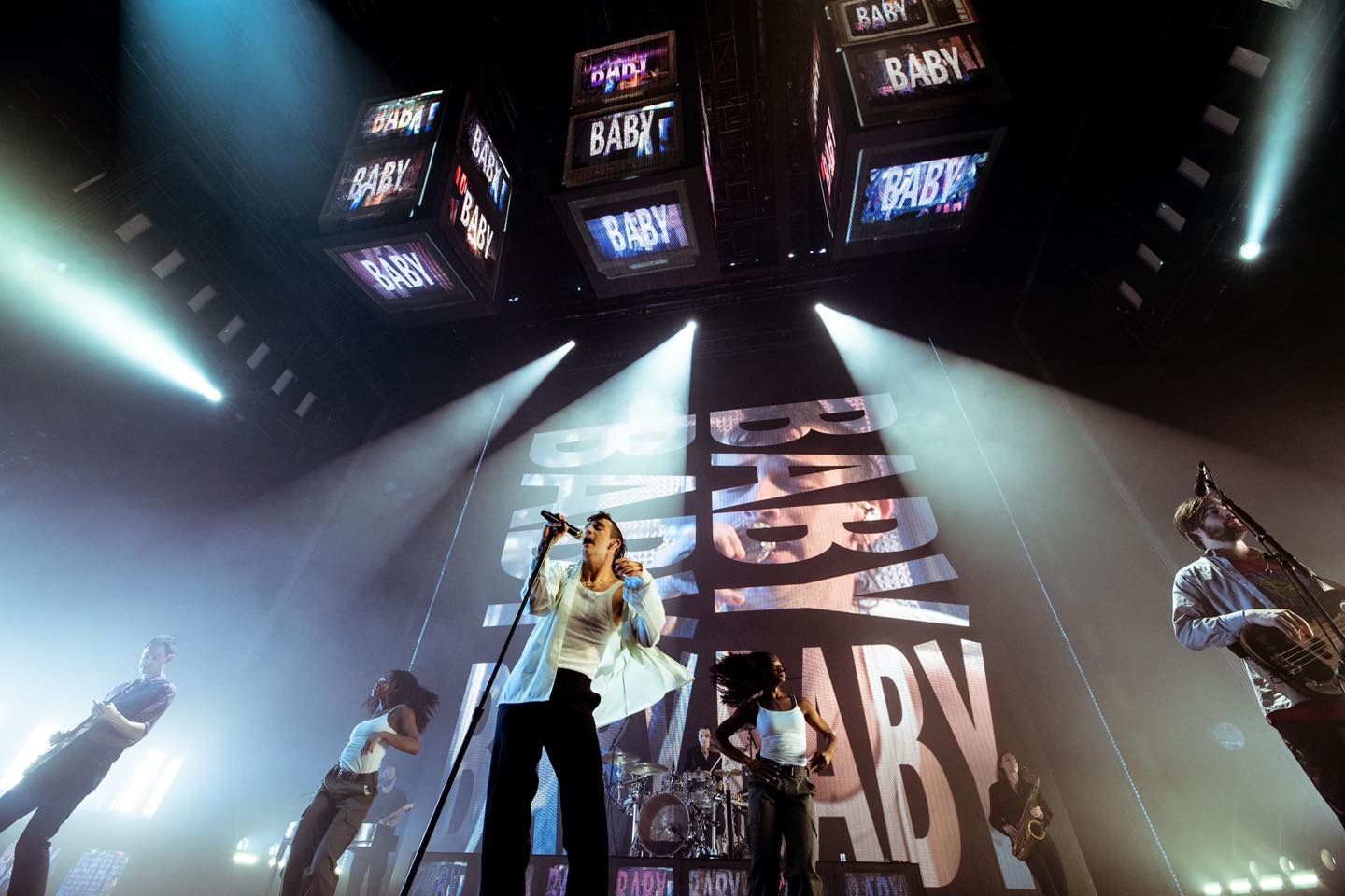 The 1975 modern concert stage setup with angled LED screens and dramatic lighting effects, directed by Ant Barrett (RESOLVE FILM)