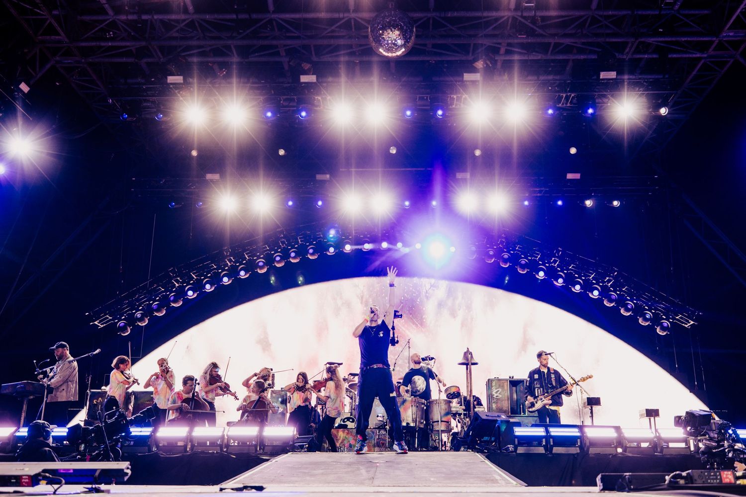 Coldplay concert stage with curved LED backdrop and dramatic lighting, directed by Ant Barrett (RESOLVE FILM)