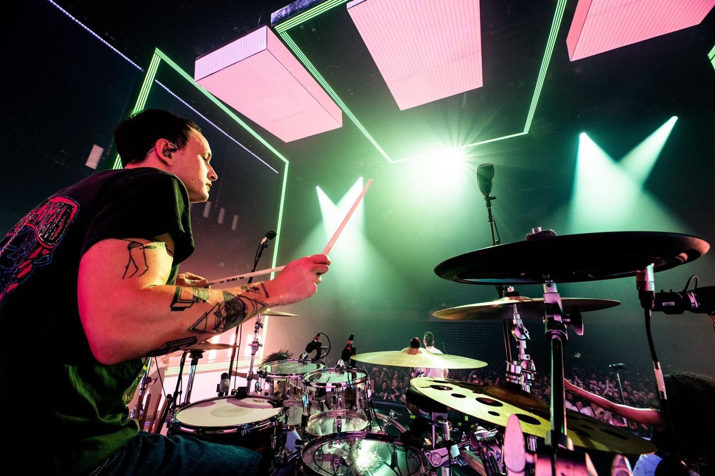 Rock performance with The 1975, green and pink stage lighting creating dynamic shadows on performers, directed by Ant Barrett (RESOLVE FILM)
