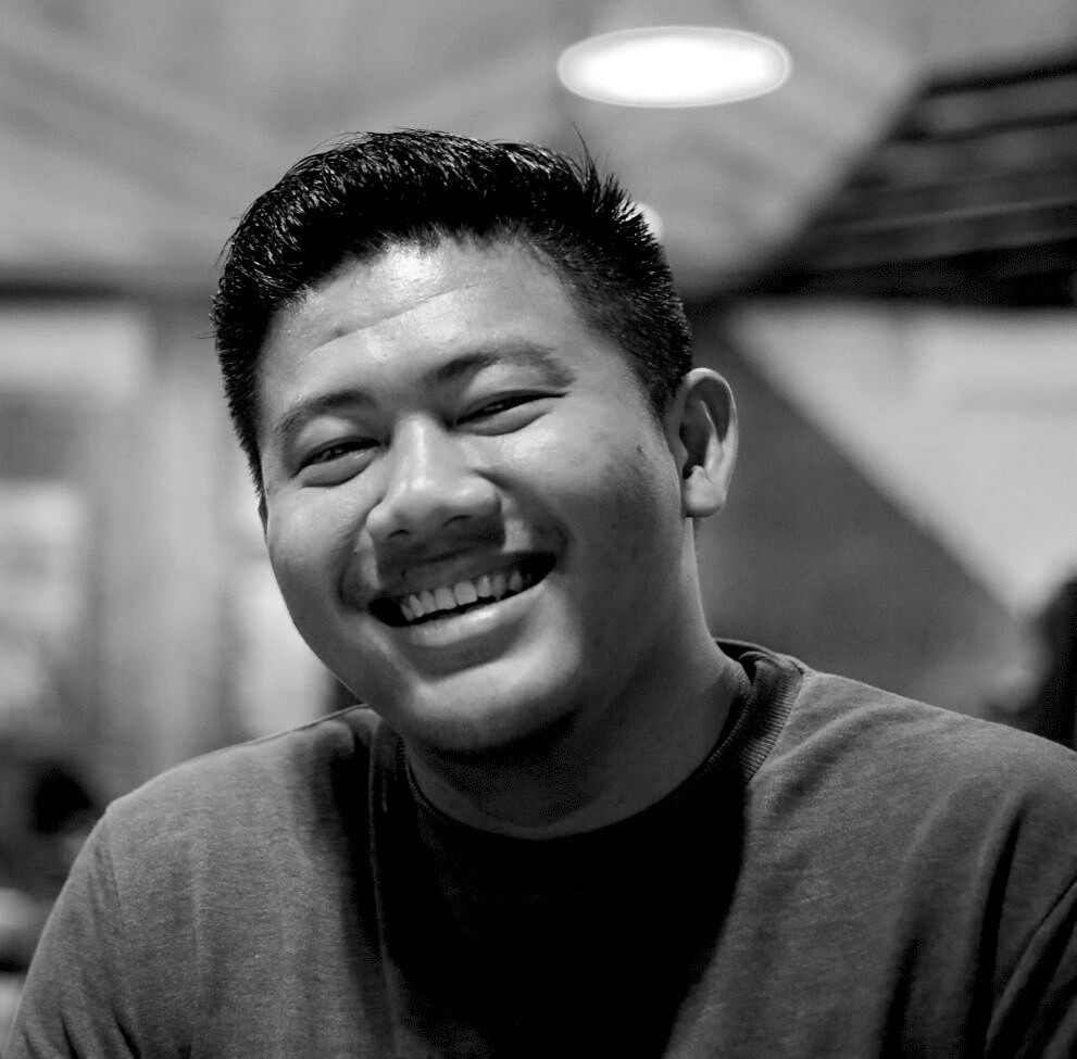 A series of black and white portraits showing a person expressing joyful emotions and genuine laughter.