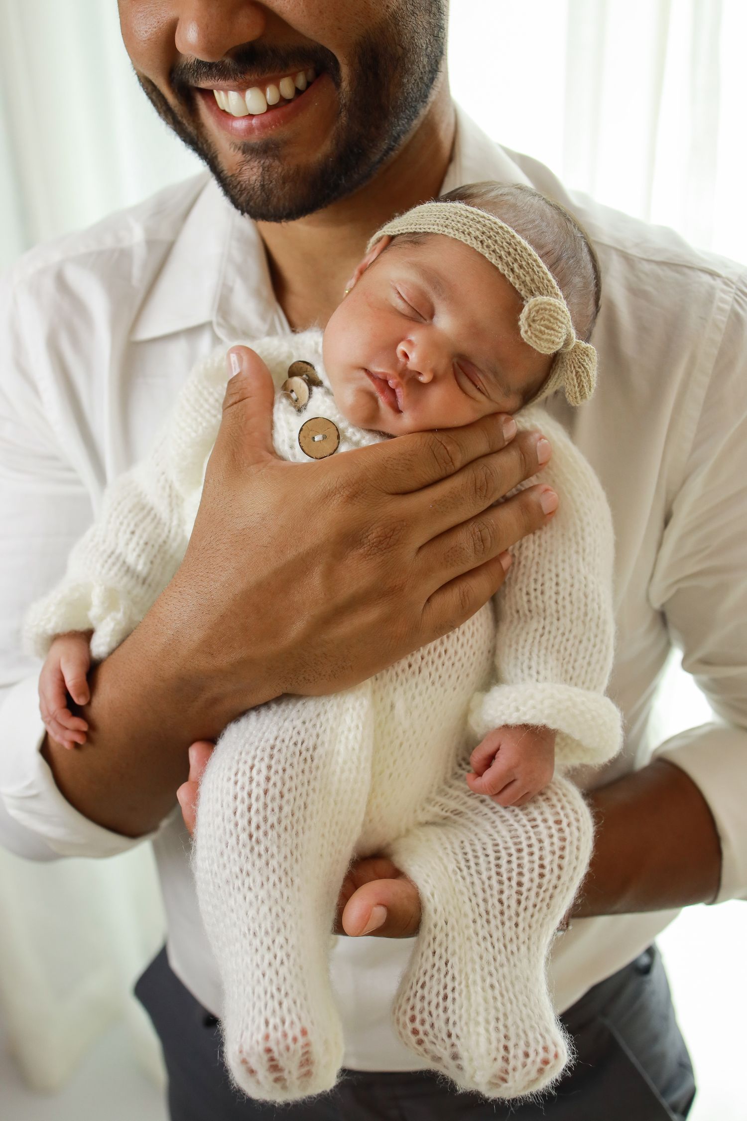 A series of tender moments showing a newborn baby wearing a white knit outfit being held and comforted.