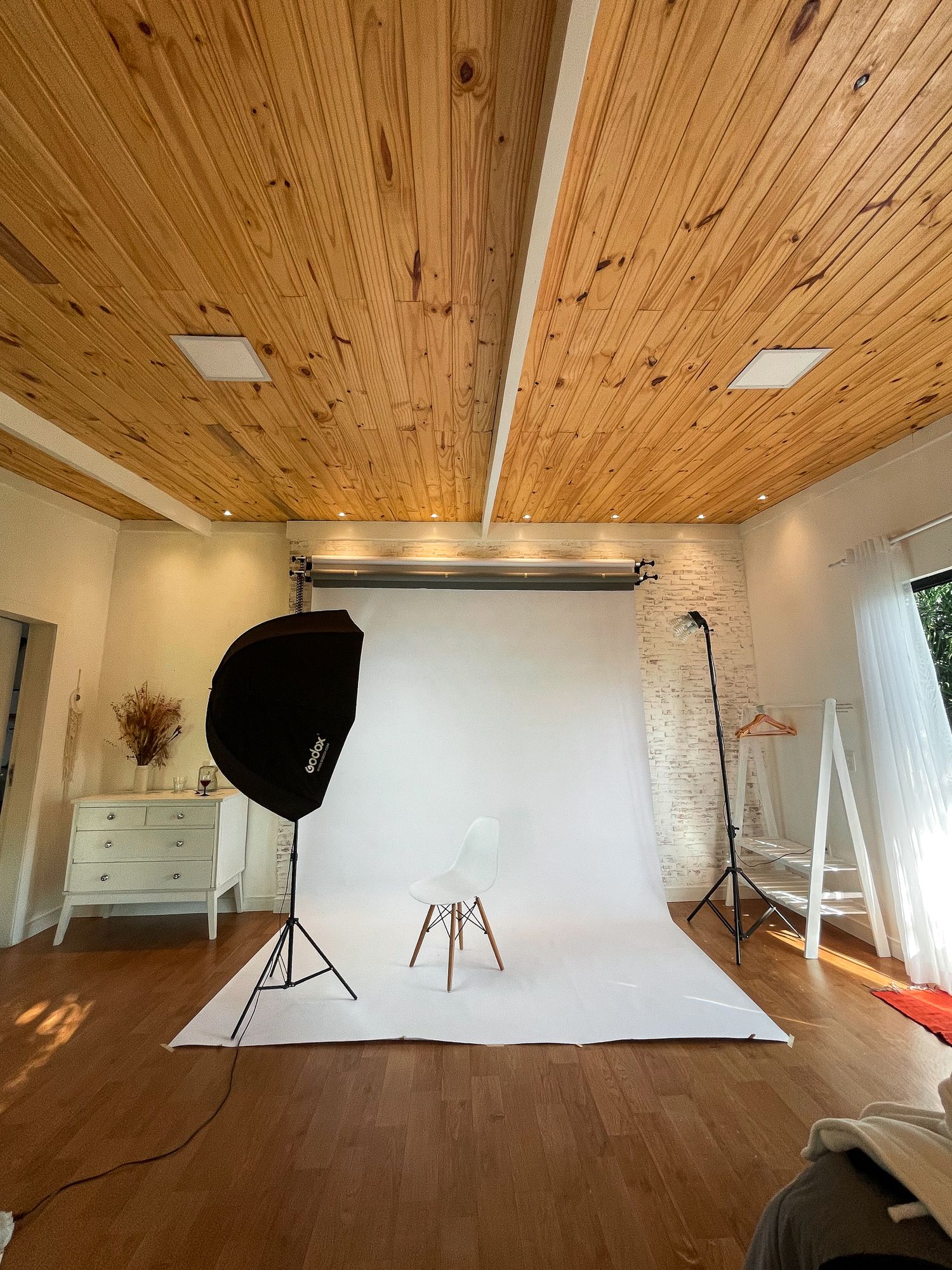 Professional photography studio setup with white backdrop and lighting equipment.