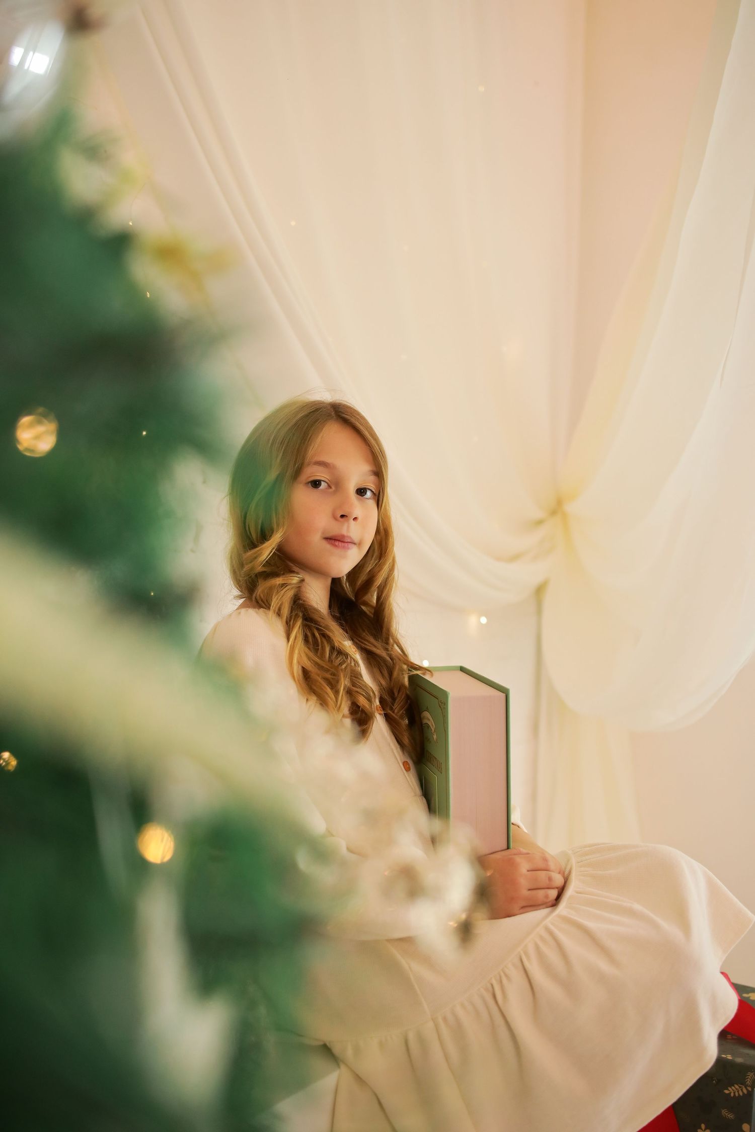 A series of dreamy photos shows a person in white flowing fabric against a soft bokeh background with curtains.