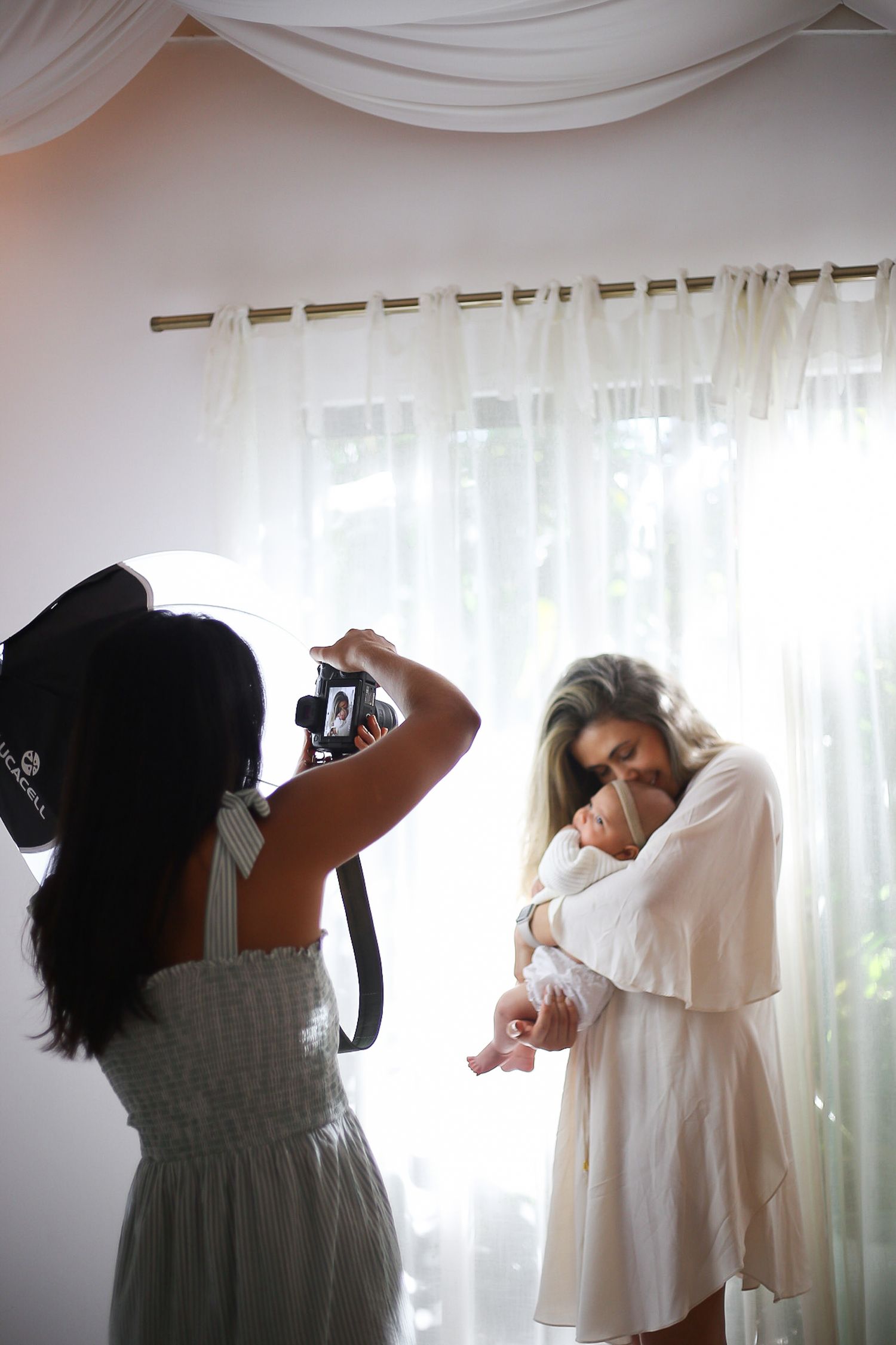 A series of artistic photographs showing people in white dresses photographing each other against a light curtained backdrop.