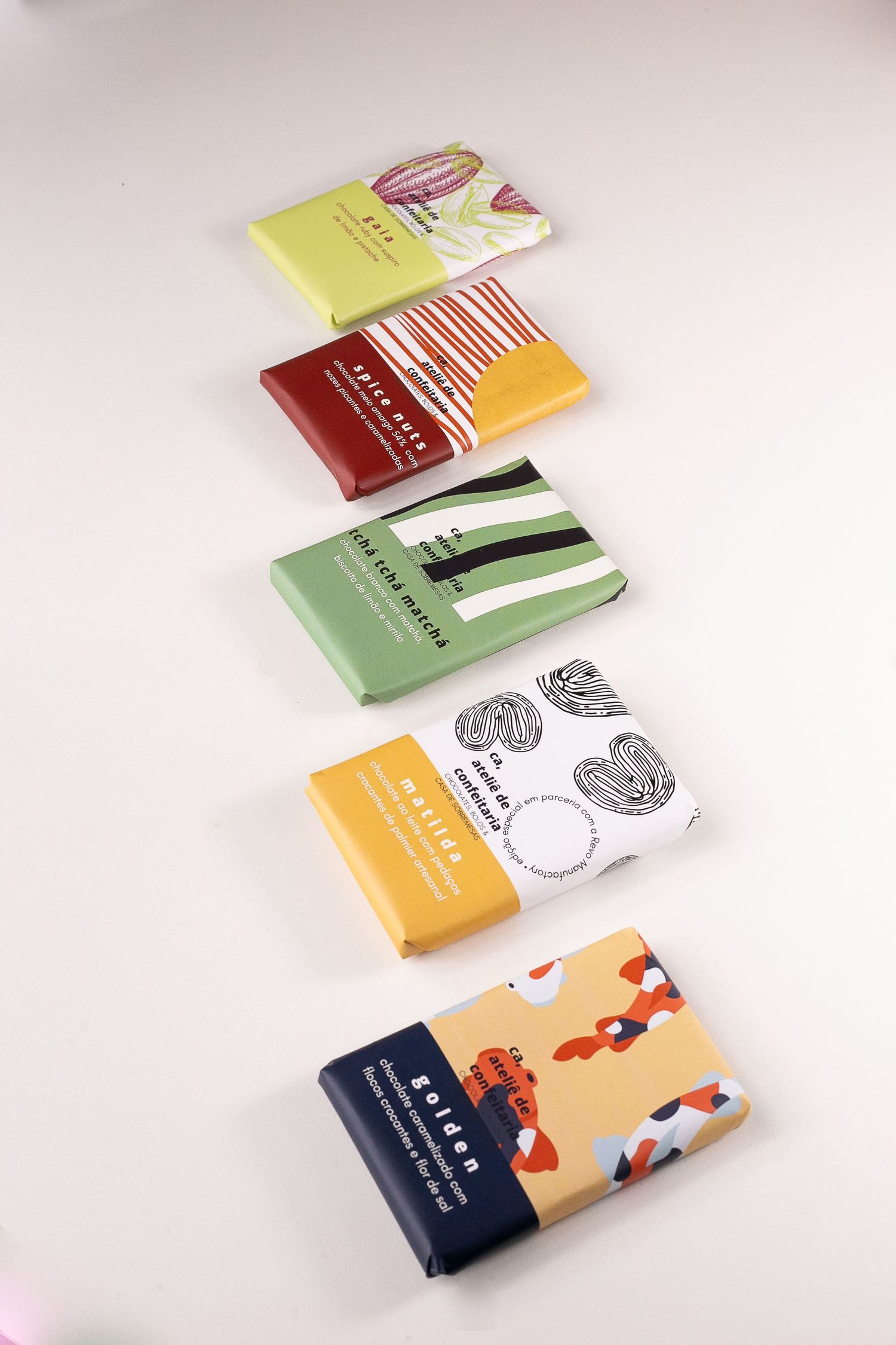 Five colorful soap bars arranged vertically on a light background showcase different patterns and packaging designs.
