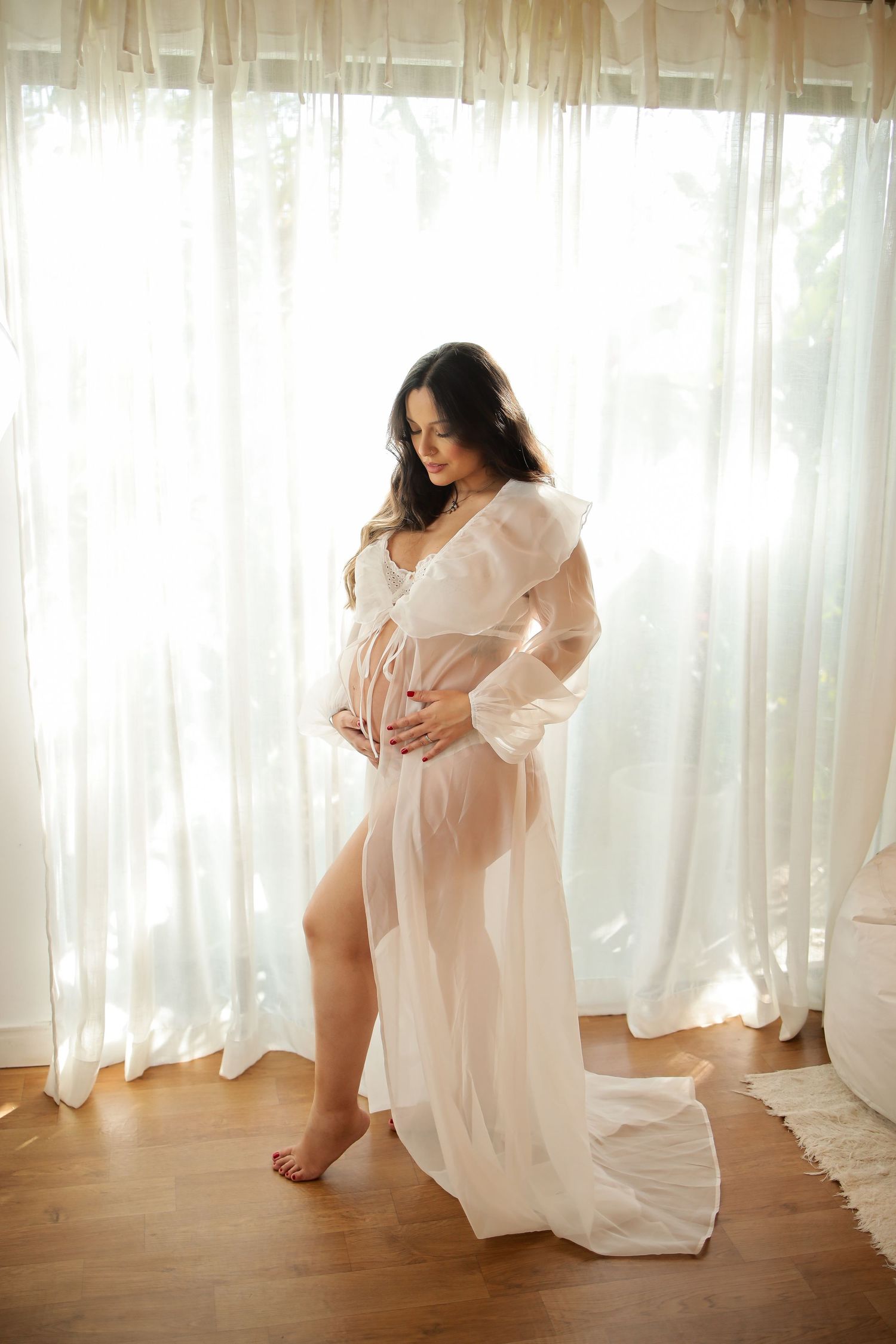 Ethereal boudoir photo series showing figure in flowing white robe against sheer curtains in natural window light.