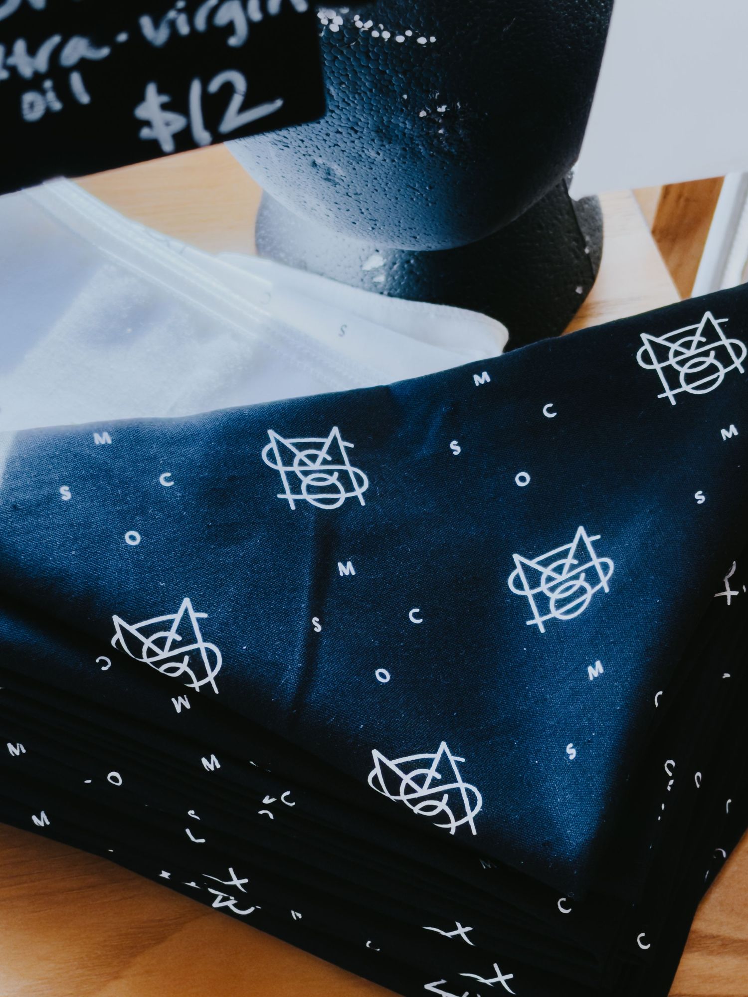 Close-up view of a dark blue fabric with white star and geometric doodle pattern printed on it.