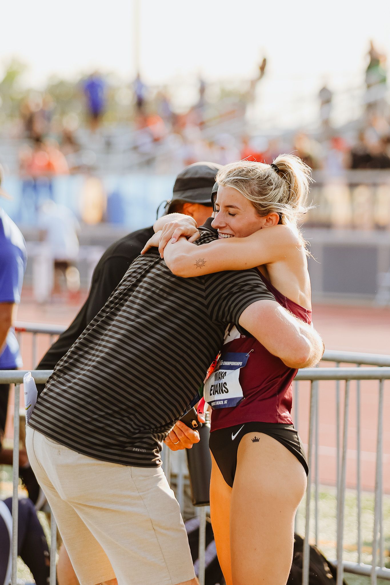 Athletes embrace in a heartfelt moment after competing in a track and field event.
