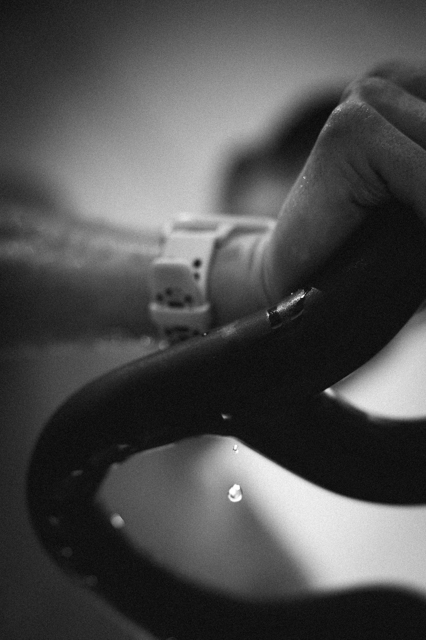 Black and white macro shot of water droplets falling in dramatic lighting.