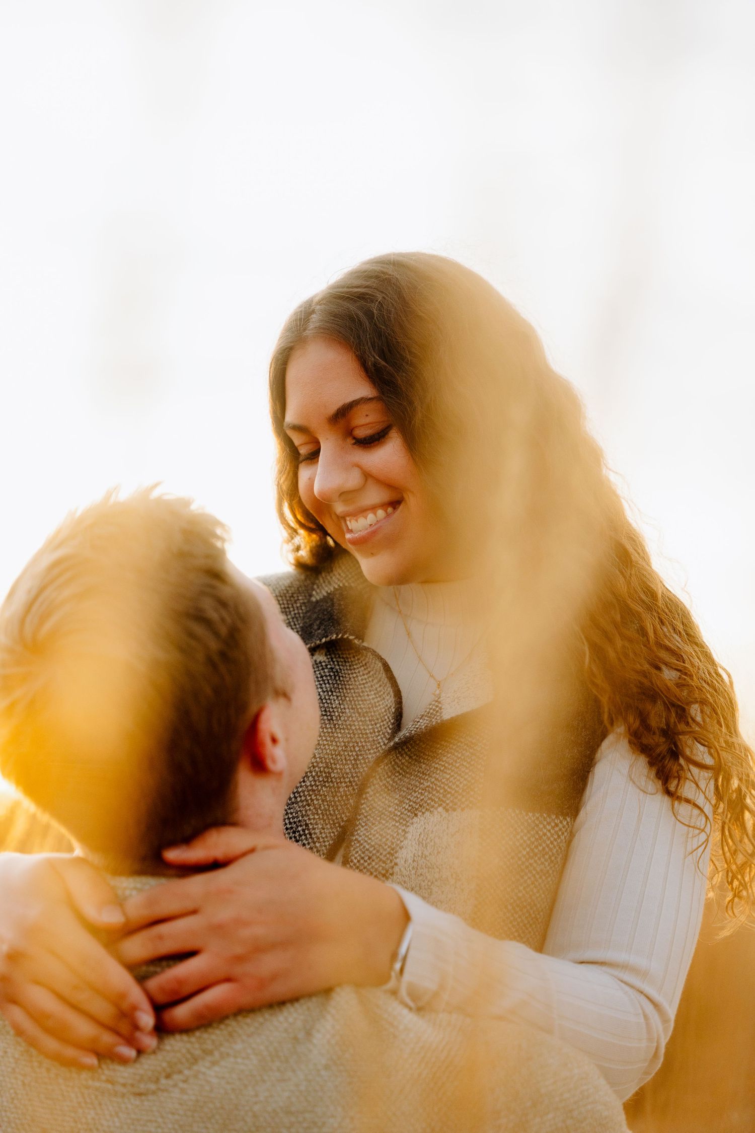 Romantic couple sharing intimate moment in warm golden sunlight.