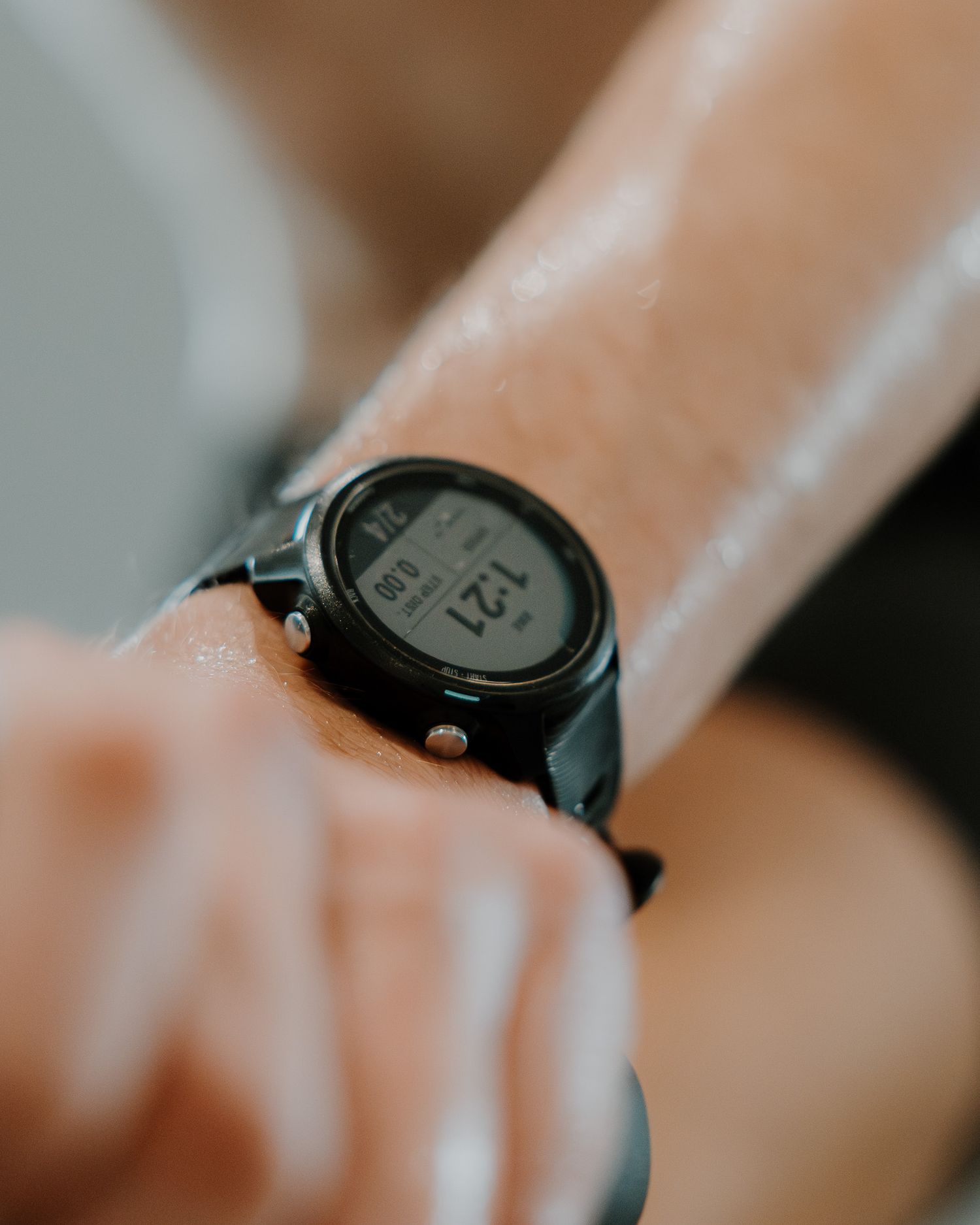 Close-up view of a black digital watch face with minimalist design against a soft blurred background.