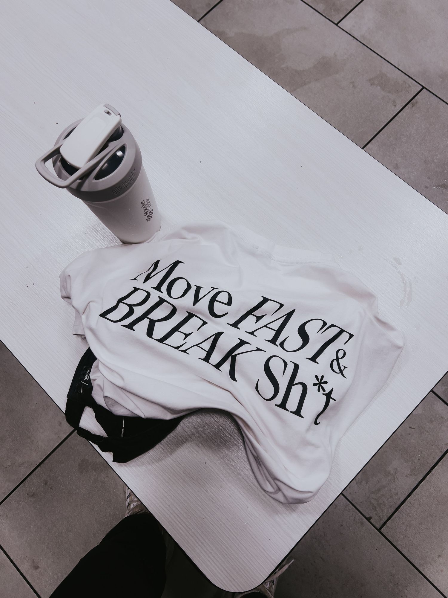 Black text on white fabric shown in a minimalist layout with dramatic shadows and lighting.