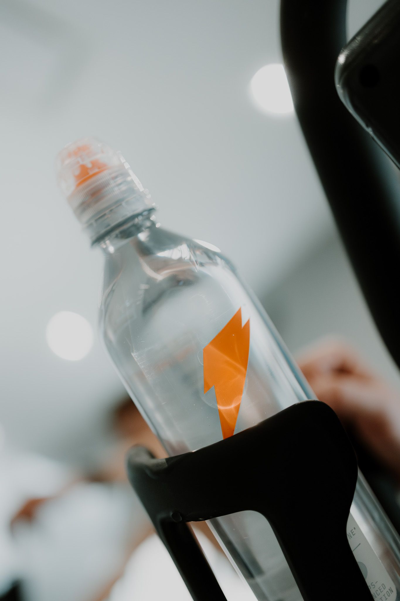 Clear plastic water bottles with orange flame logos arranged in a row on a light surface.