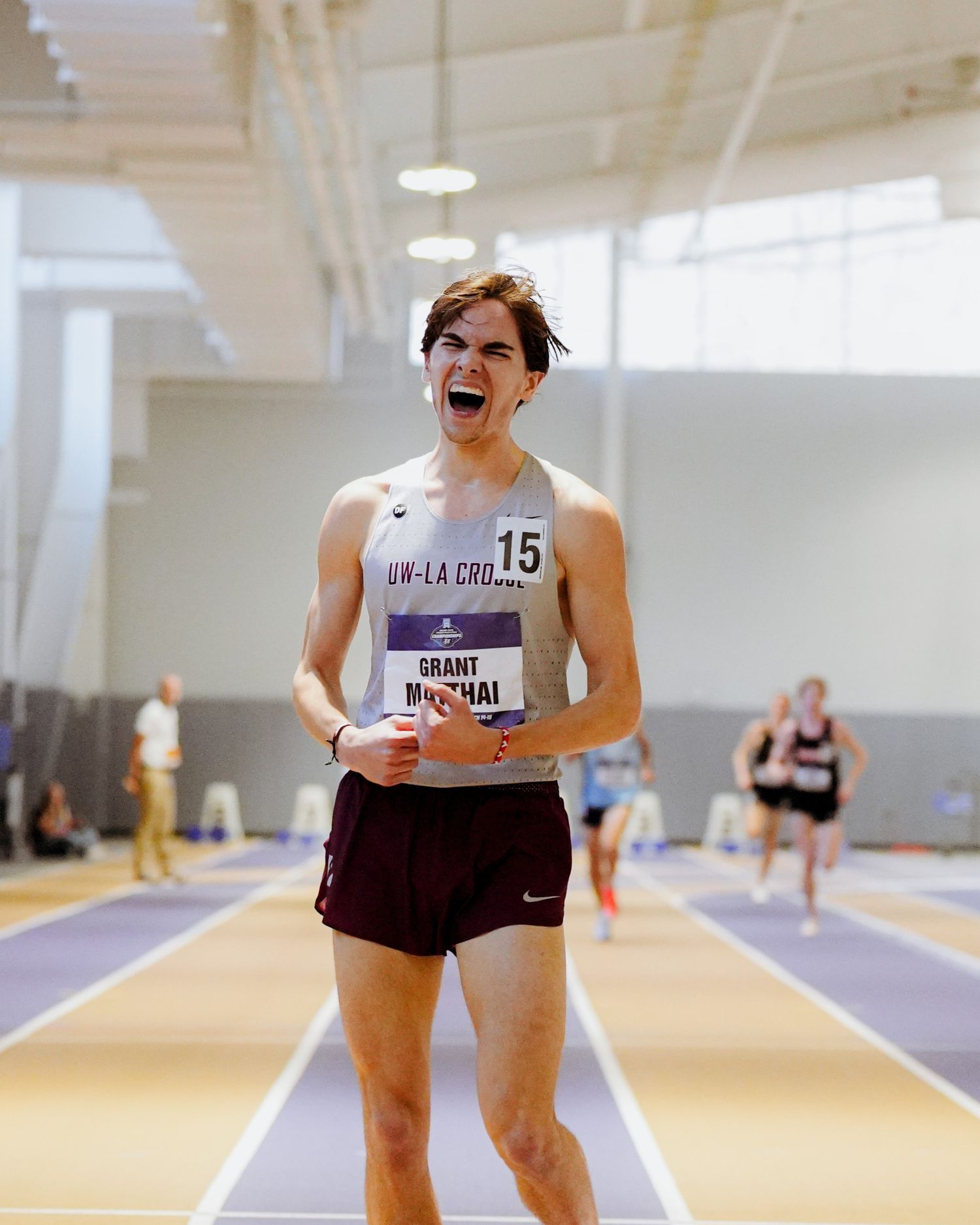 Athletes laughing and enjoying themselves during an indoor track and field training session.