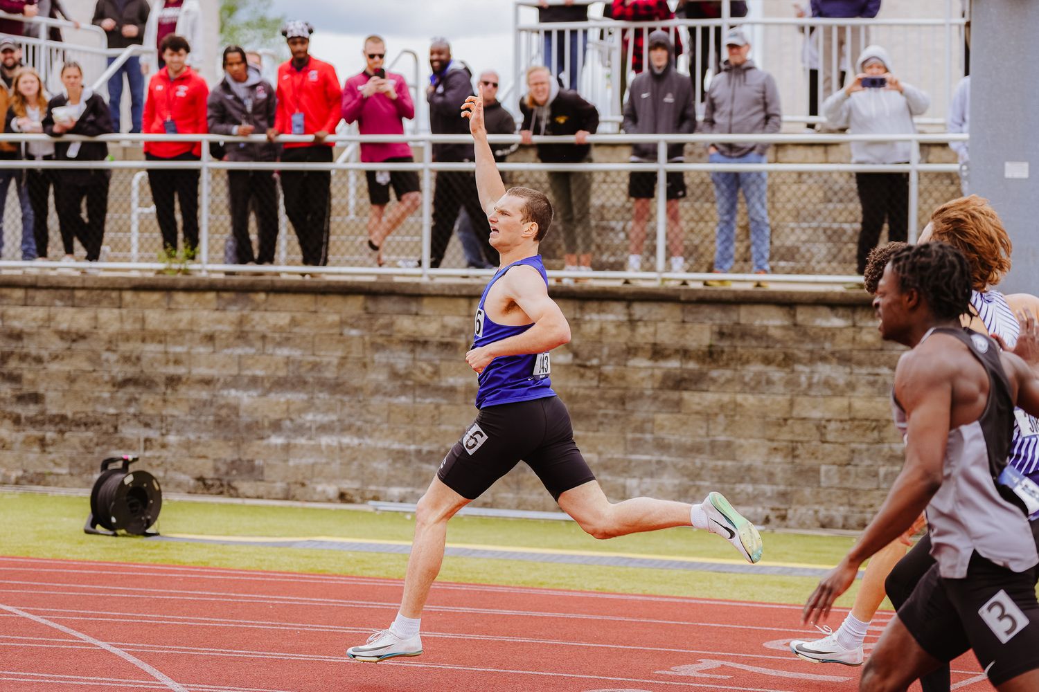 Athletes competing in a track and field race on an outdoor running track.